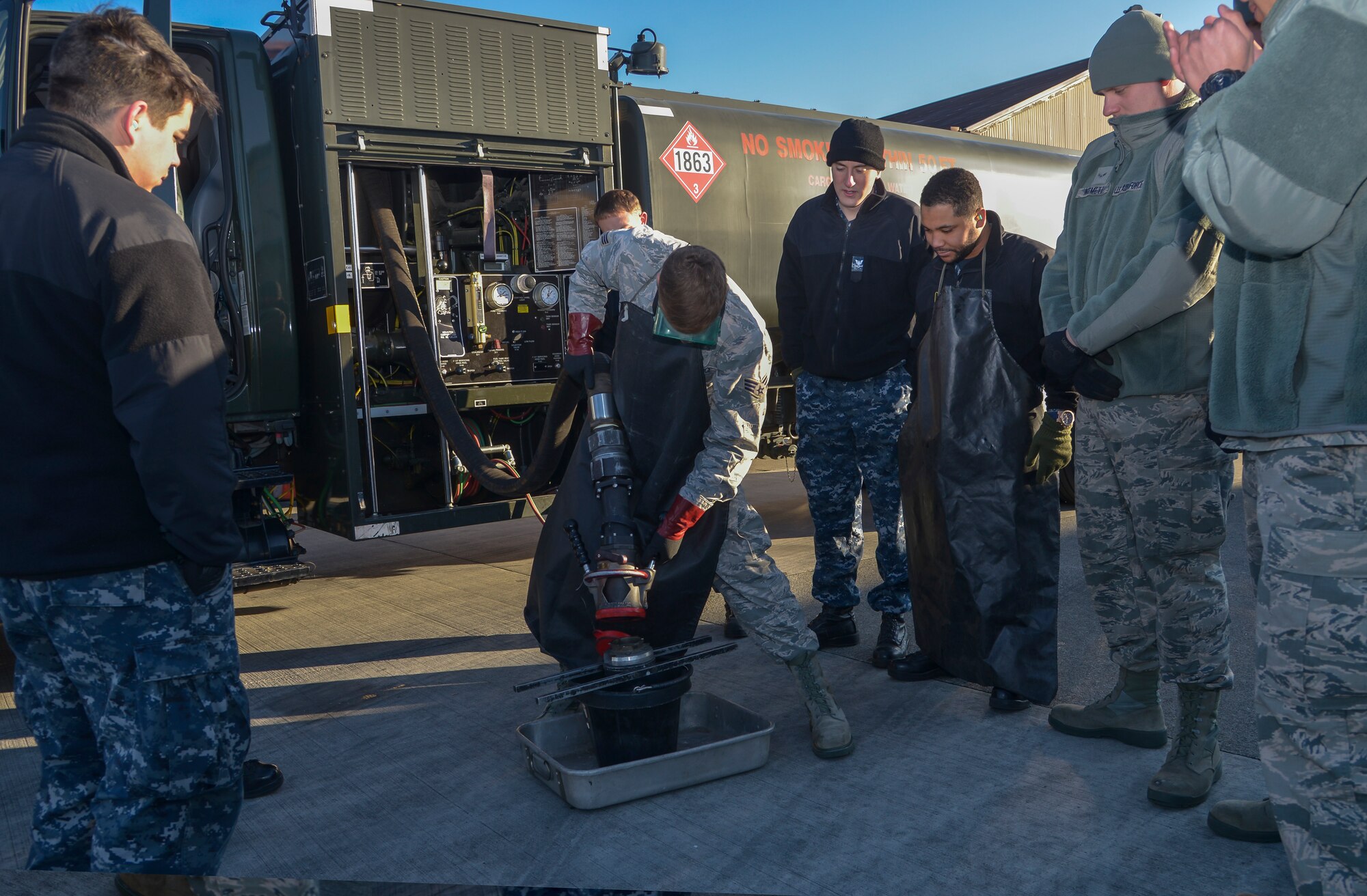 Senior Airman Tyler Sims, 374th Logistics Readiness Squadron fuels management flight fuels training supervisor, shows Sailors from Naval Air Facility Atsugi how to properly remove a fuel hose nozzle at Yokota Air Base, Japan, Jan. 26, 2016. The training allowed members to be prepared to support U.S. Navy aircraft at Anderson Air Force Base, Guam, during the exercise Cope North. (U.S. Air Force photo by Senior Airman David Owsianka/Released)