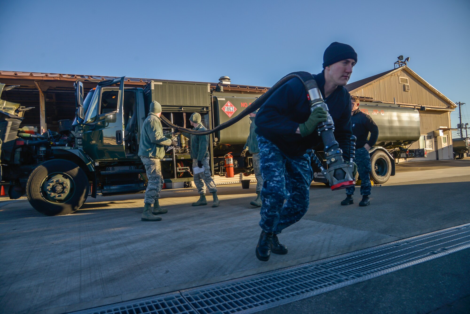 Petty Officer 3rd Class Christian Fakhoury, Naval Air Field Atsugi Carrier Airborne Early Warning Squadron administrative assistant, pulls a fuel hose for daily inspection at Yokota Air Base, Japan, Jan. 26, 2016. The Navy personnel who received training on the R-11 refueling trucks learned how to drive, service aircraft, perform minor maintenance and how to check fuel samples. (U.S. Air Force photo by Senior Airman David Owsianka/Released)