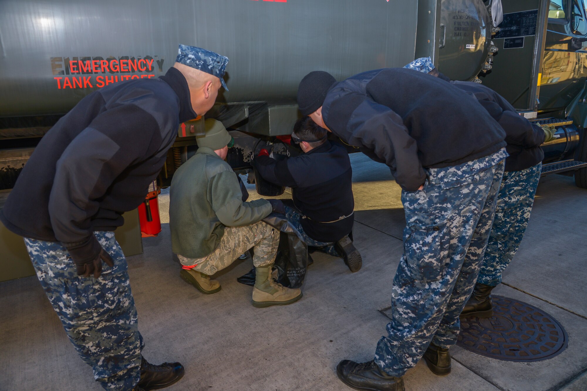 Members from Naval Air Facility Atsugi observe as personnel take JP-8 fuel samples from an R-11 refueling trucks at Yokota Air Base, Japan, Jan. 26, 2016. The training allowed members to be prepared to support U.S. Navy aircraft at Anderson Air Force Base, Guam, during the exercise Cope North. (U.S. Air Force photo by Senior Airman David Owsianka/Released)