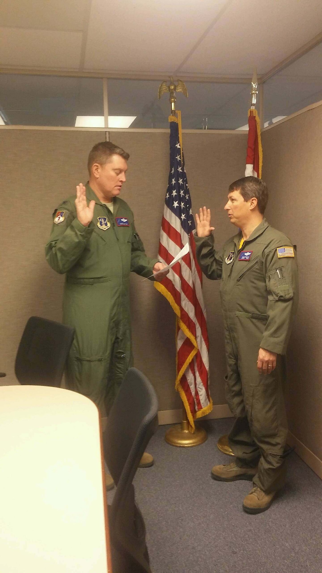 U.S. Air Force Col. Todd Mitton (left), Missouri National Guard A-3 director of operations, reads the oath of enlistment to his brother-in-law, Chief Master Sgt. David Schultz, 139th Operations Group superintendent, on Jan. 28, 2016 at Rosecrans Air National Guard Base. (Courtesy photo)