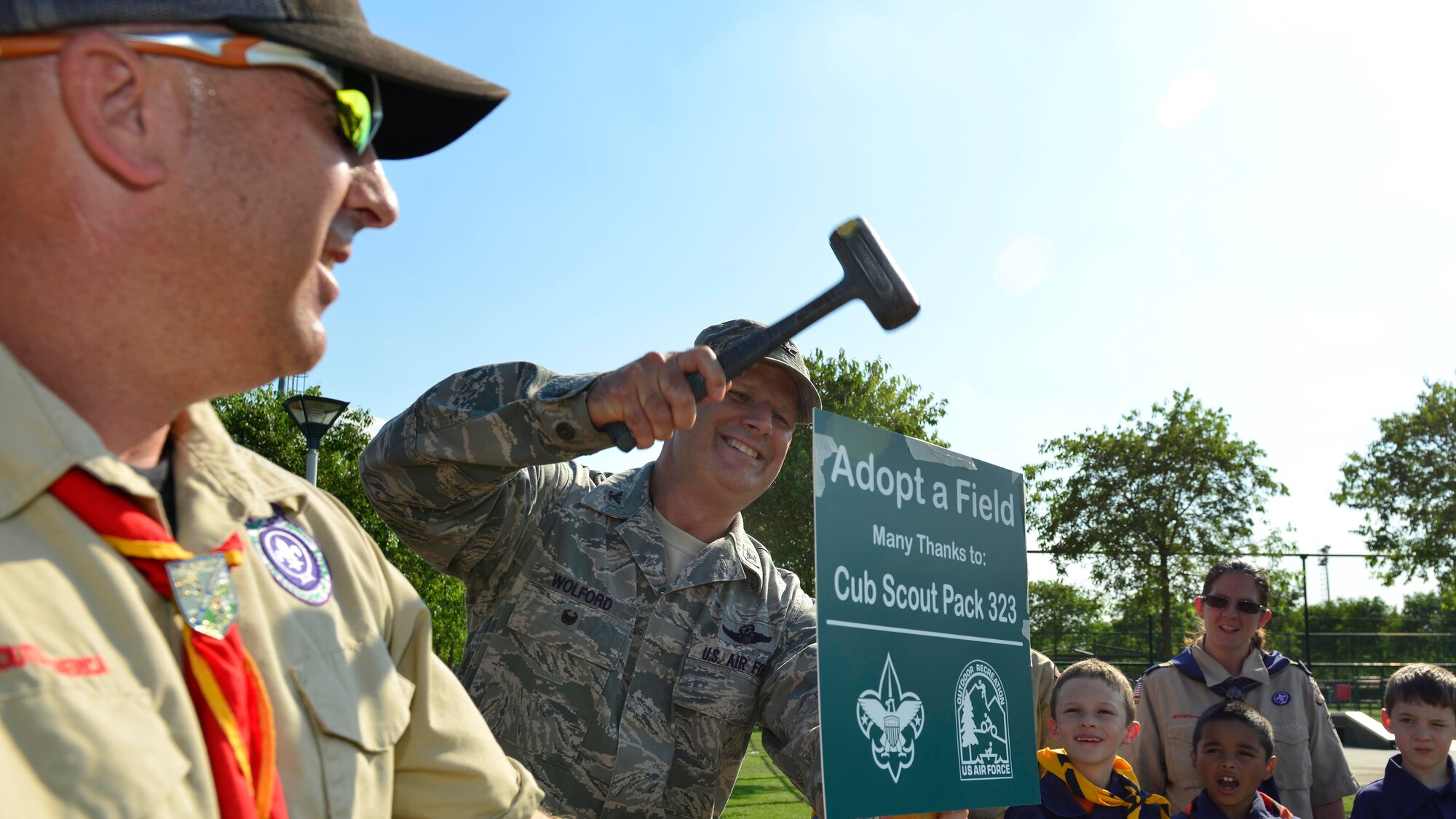 Col. Bryan Wolford, 31st Fighter Wing vice commander, hammers the “adopt a field” sign into the ground into during a ceremony, June 29, 2016, at Aviano Air Base, Italy. Aviano Cub Scouts Pack 323 took on the responsibility to manage the cleanliness of Freedom Park. (U.S. Air Force photo by Airman 1st Class Cary Smith/Released)