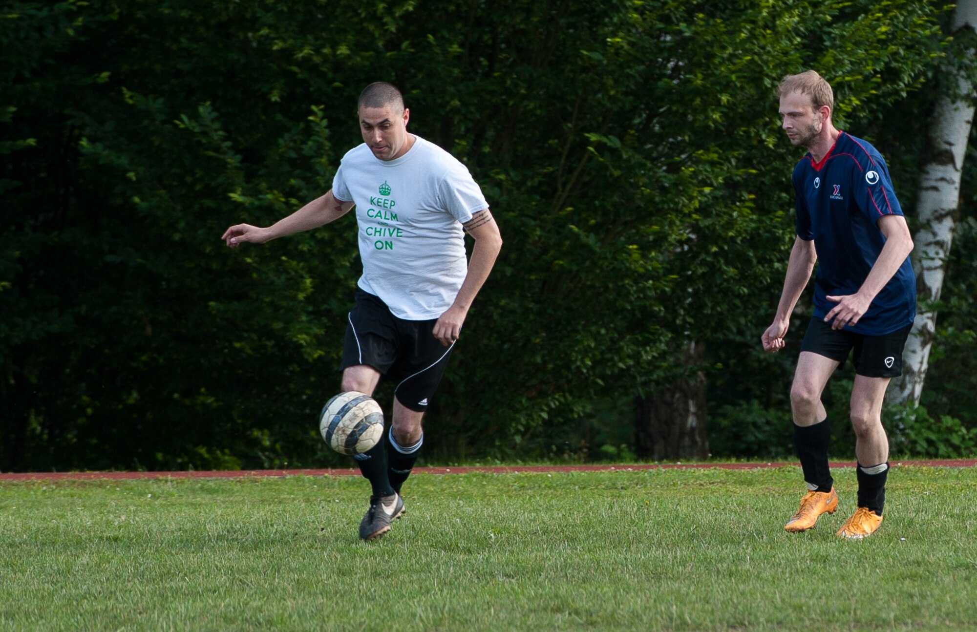 Staff Sgt. Nick Sandoval, 76th Airlift Squadron flight attendant, dribbles a soccer ball forward past his opponent during the Ramstein intramural soccer finals June 29, 2016, at Ramstein Air Base, Germany. Intramural sports are one of many ways Airmen can stay fit and competitive throughout the year, and allow participants to enhance their camaraderie and communicative abilities. (U.S. Air force photo/Airman 1st Class Lane T. Plummer)
