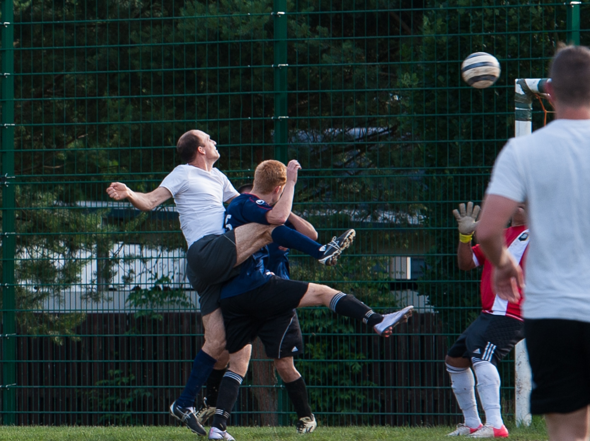Maj. Casey Chronister, 76th Airlift Squadron C-21 instructor pilot, towers over his defender as he uses his head to hit the ball toward the goal and tries to score during the Ramstein intramural soccer finals June 29, 2016, at Ramstein Air Base, Germany. The Ramstein intramural soccer season lasts between April and June every year, where units all around Ramstein participate in teams of up to 11 and compete to finish well enough in their table to make it to finals. (U.S. Air force photo/Airman 1st Class Lane T. Plummer)