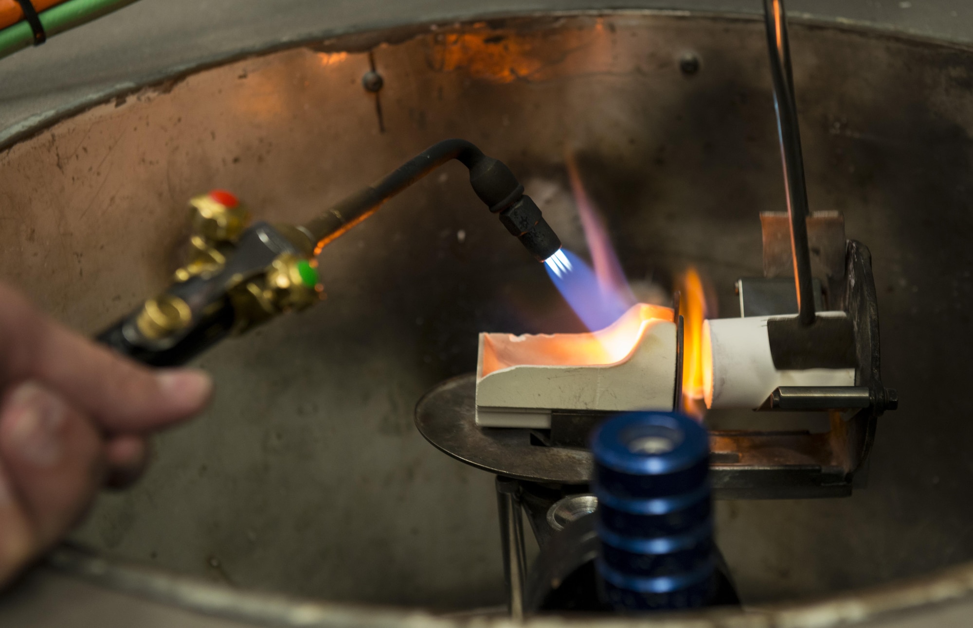 Jim Patterson, 86th Dental Squadron dental lab technician, melts gold for a tooth crown June 30, 2016, at Ramstein Air Base, Germany. After melting the gold, Patterson spun it at high speeds to push it into a ready-made mold. (U.S. Air Force photo/Airman 1st Class Tryphena Mayhugh)