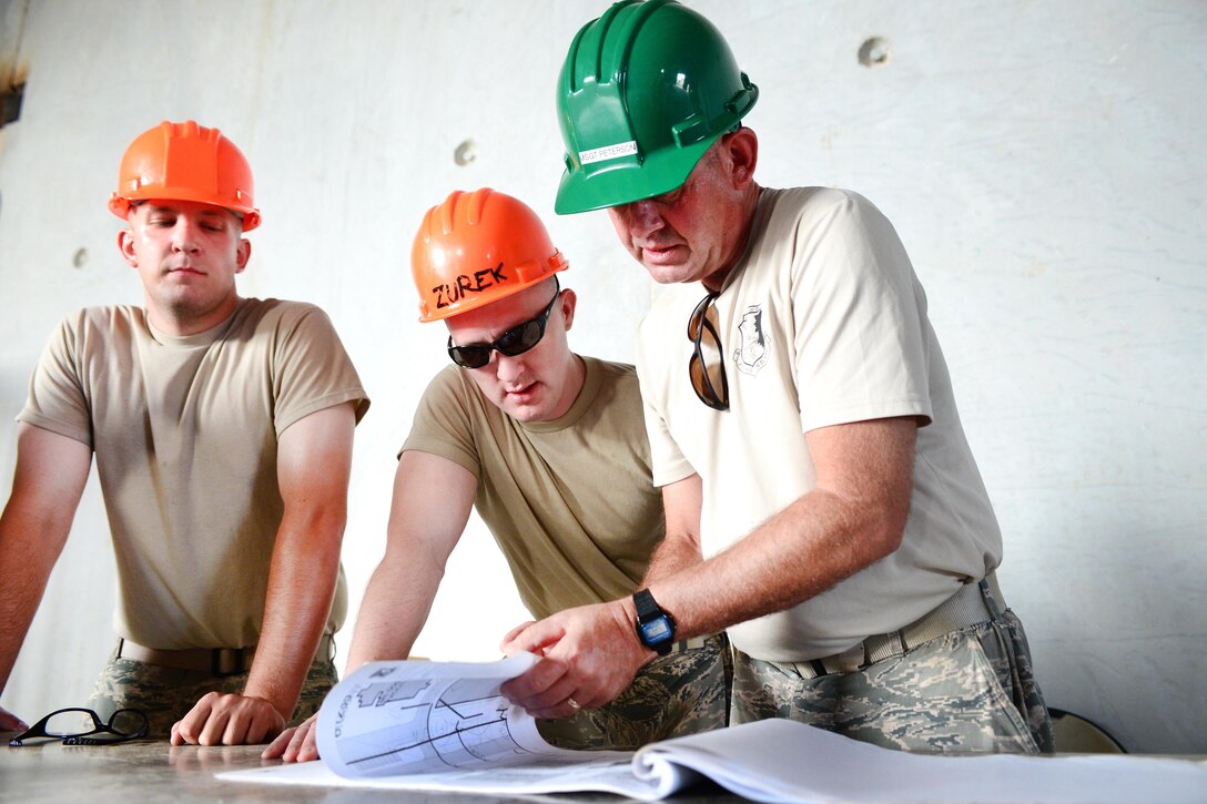 Left to right: Airman First Class Matthew Johnson, Staff Sgt. William Zurek, and Master Sgt. Daniel Peterson review design plans for construction of the Commando Warrior Field Training Facility at Andersen Air Force Base, Guam, June 20, 2016. Johnson, Zurek, and Peterson are assigned to the New Hampshire Air National Guard’s 157th Civil Engineering Squadron. The squadron is deployed to Guam for annual training where they are working on a construction project for the Pacific Command Regional Training Center. Air National Guard photo by Airman 1st Class Ashlyn J. Correia