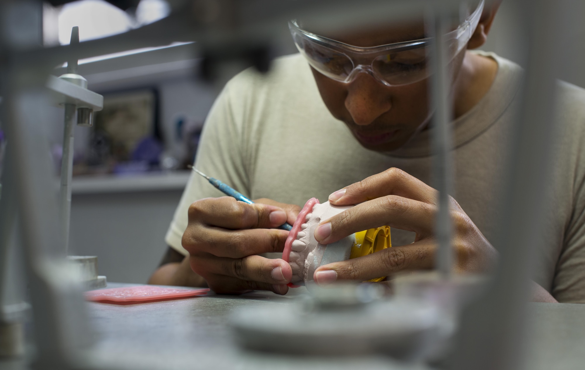 Airman 1st Class Jesus Benitez, 86th Dental Squadron dental lab technician, works on a hard night guard June 30, 2016, at Ramstein Air Base, Germany. The dental lab is divided into two sections, the base dental lab and the area dental lab. The base dental lab provides for Ramstein, while the area dental lab provides for several bases throughout U.S. Air Forces in Europe. (U.S. Air Force photo/Airman 1st Class Tryphena Mayhugh)