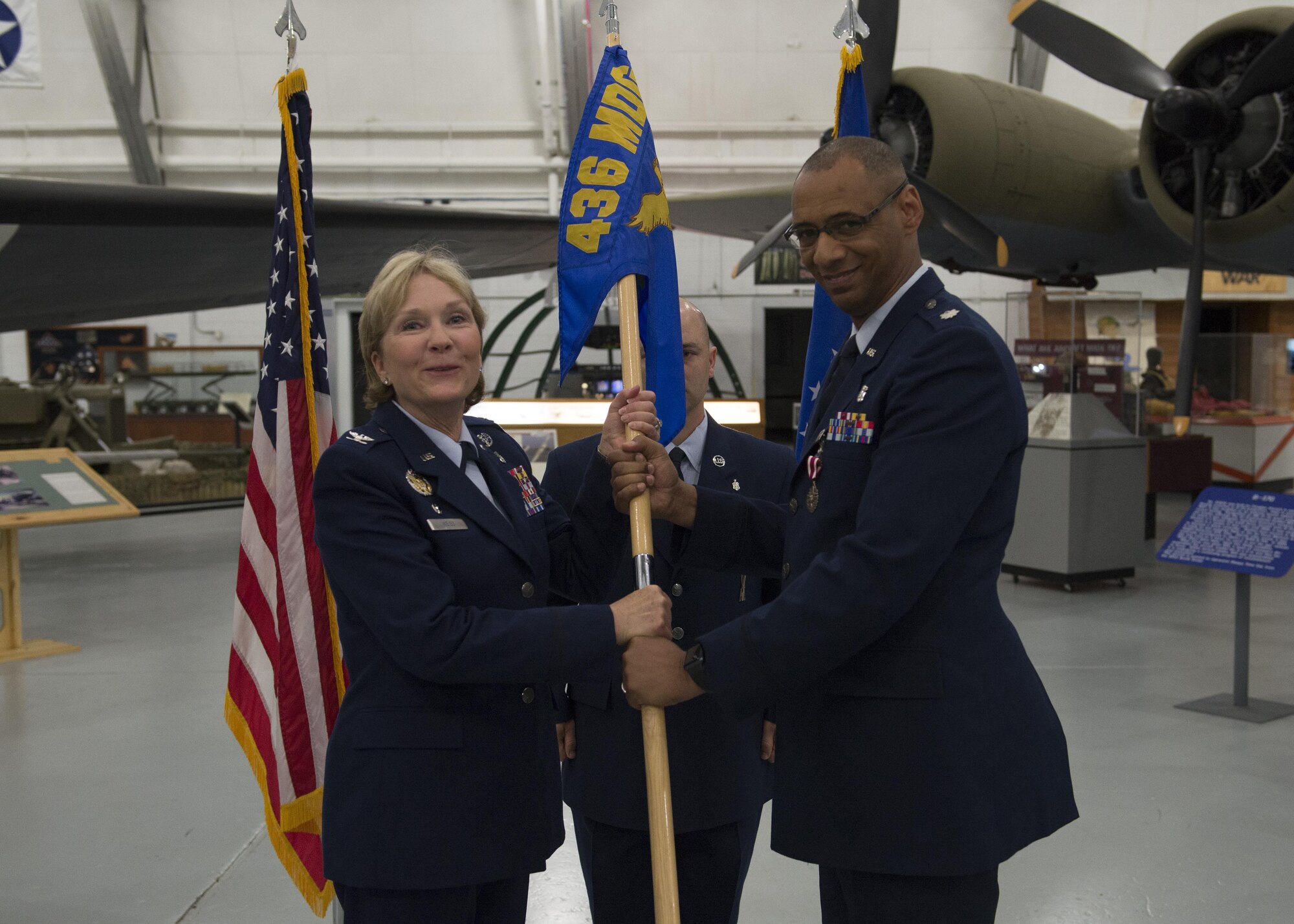 Lt. Col. Eric Baugh, 436th Dental Squadron out-going commander, relinquishes command by handing off his squadron’s guidon to Col. Kathryn Weiss, 436th Medical Group commander, during the 436th Dental Squadron Inactivation Ceremony on June 28, 2016, at the Air Mobility Command Museum on Dover Air Force Base, Del. The 436th DS will now be designated as the 436th Dental Flight, subordinate to the 436th Aerospace Medicine Squadron. (U.S. Air Force photo/Senior Airman Zachary Cacicia)