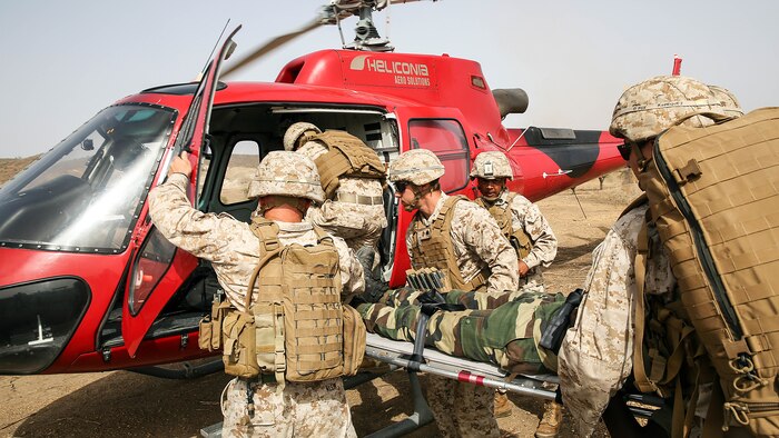 U.S Marines with Special Purpose Marine Air-Ground Task Force Crisis Response-Africa load a simulated casualty to a helicopter during a medivac rehearsal with the Compagnie Fusilier de Marin Commando in Thies, Senegal, June 21, 2016. This is the first time Marines and the COFUMACO have used a helicopter for medical assistance during training in Senegal. This new capability saves valuable time should an injury occur during live-fire ranges. 
