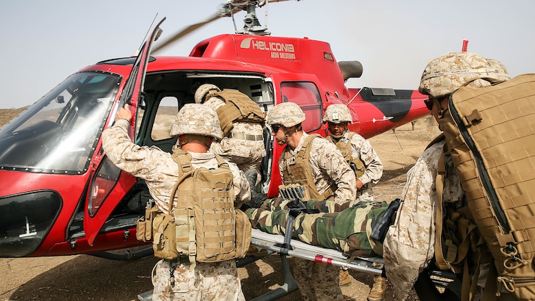 U.S Marines with Special Purpose Marine Air-Ground Task Force Crisis Response-Africa load a simulated casualty to a helicopter during a medivac rehearsal with the Compagnie Fusilier de Marin Commando in Thies, Senegal, June 21, 2016. This is the first time Marines and the COFUMACO have used a helicopter for medical assistance during training in Senegal. This new capability saves valuable time should an injury occur during live-fire ranges. 