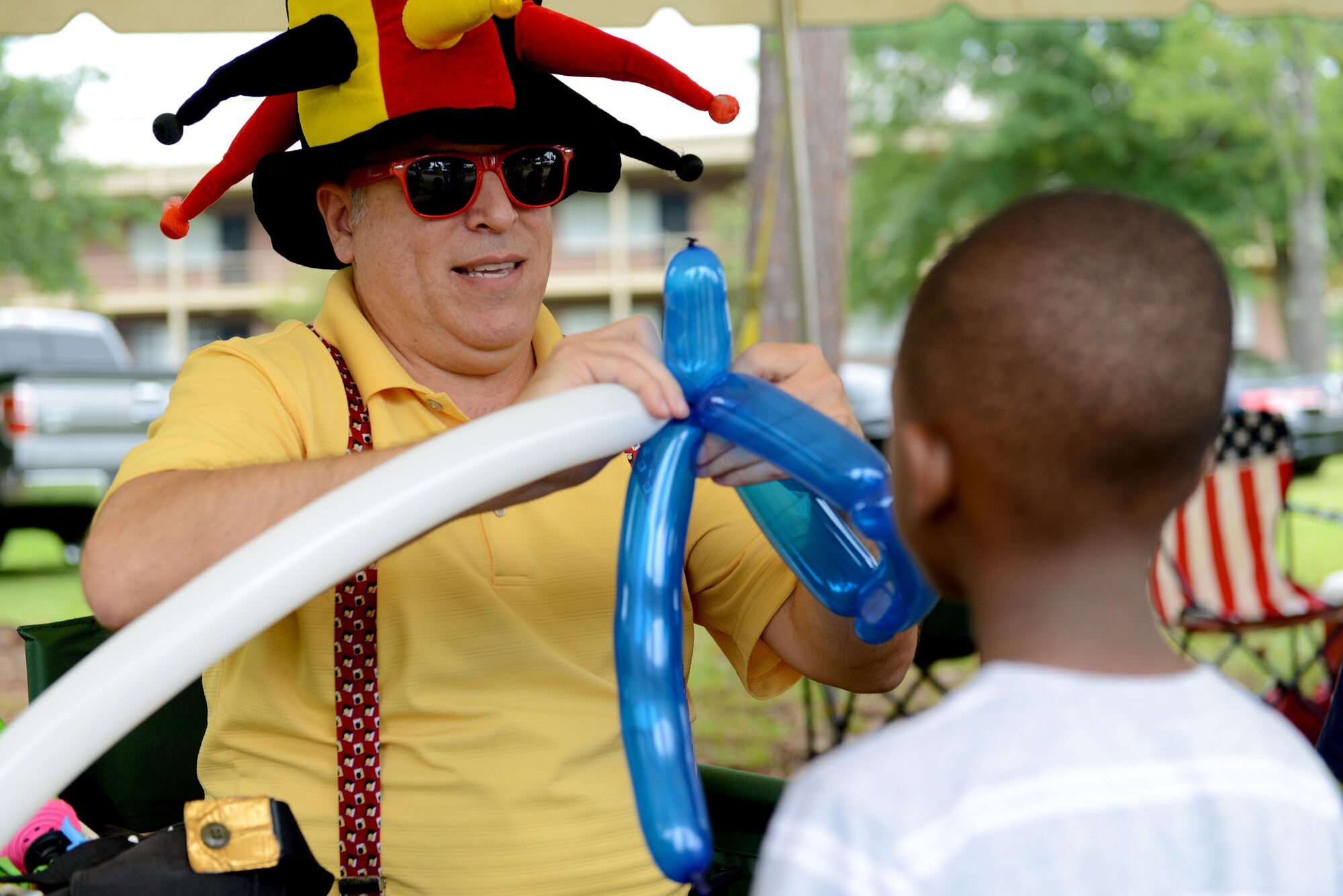 An entertainer makes a balloon animal for a child during the Shaw Freedom Bash at Shaw Air Force Base, S.C., June 30, 2016. The 20th Force Support Squadron hosted the Shaw Freedom Bash to celebrate Independence Day. (U.S. Air Force photo by Airman 1st Class Destinee Dougherty)