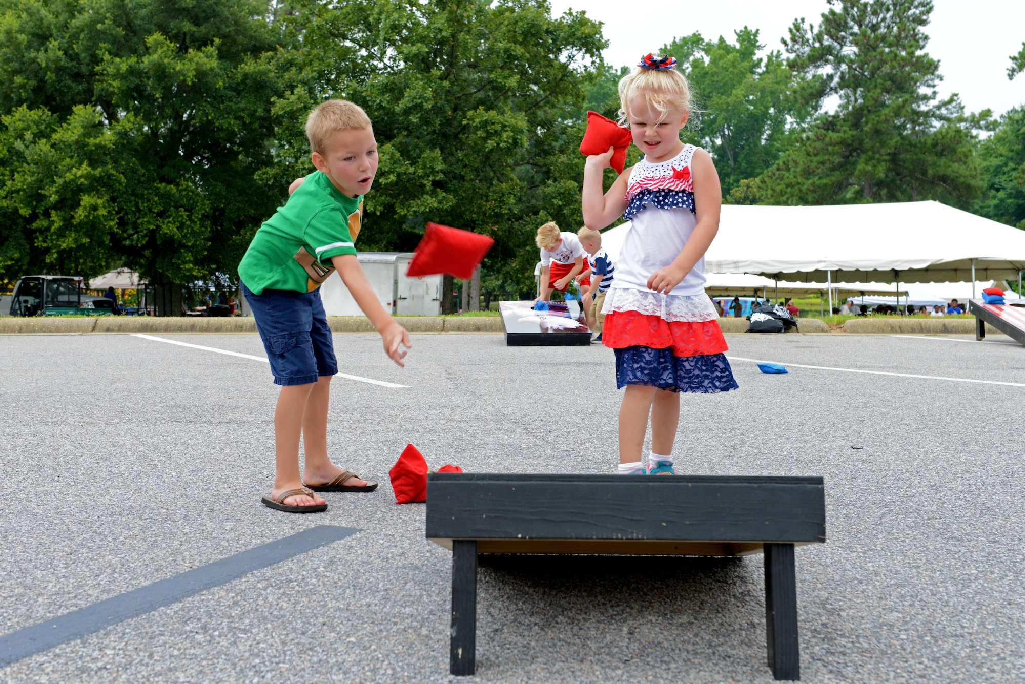 Two Team Shaw children play cornhole during the Shaw Freedom Bash at Shaw Air Force Base, S.C., June 30, 2016. The Freedom Bash featured several activities including a live band, pool games and balloon animals. (U.S. Air Force photo by Airman 1st Class Destinee Dougherty)