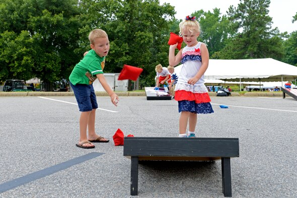 Two Team Shaw children play cornhole during the Shaw Freedom Bash at Shaw Air Force Base, S.C., June 30, 2016. The Freedom Bash featured several activities including a live band, pool games and balloon animals. (U.S. Air Force photo by Airman 1st Class Destinee Dougherty)