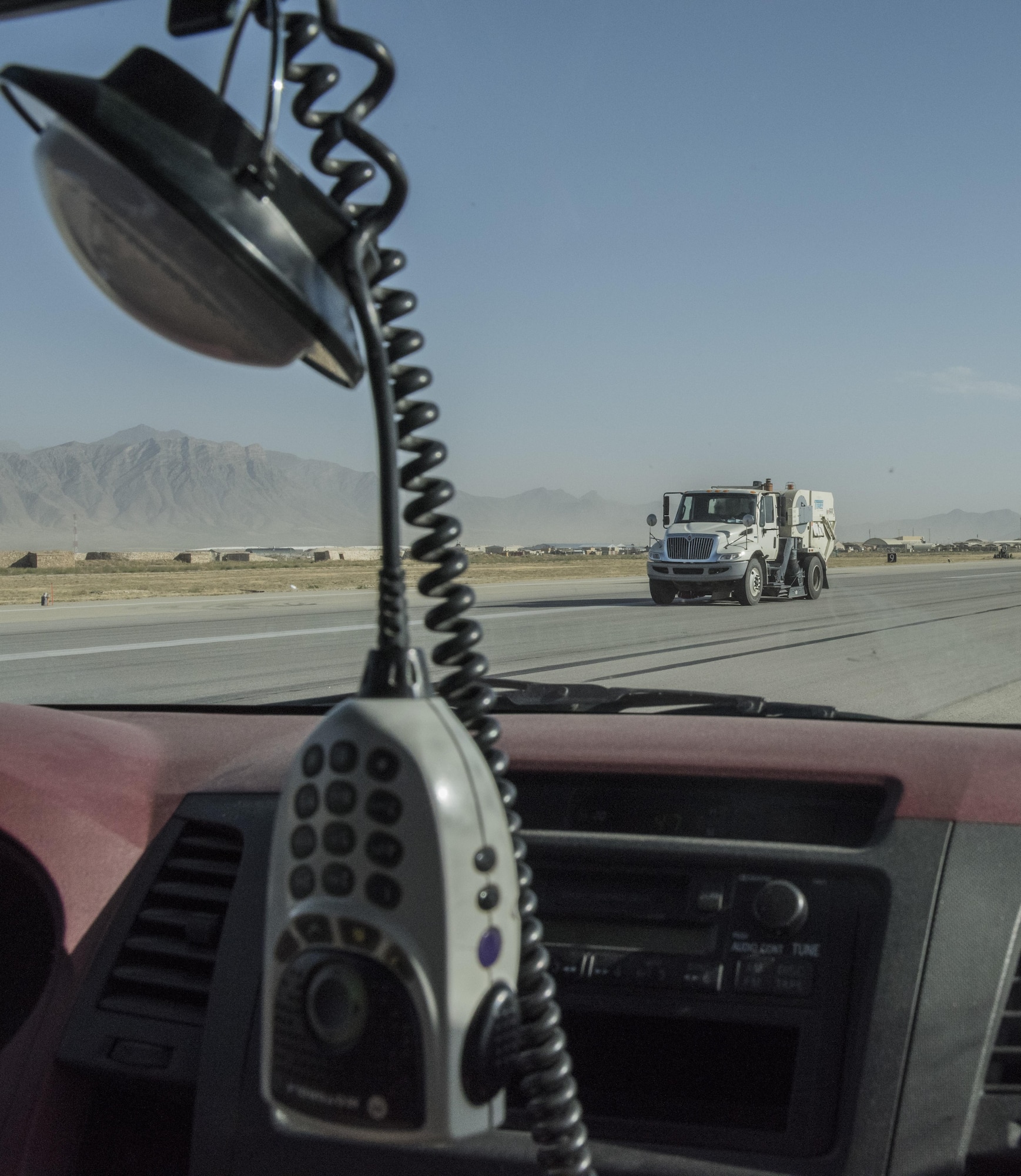 A ground sweeper clears the runway after a wide body aircraft lands on the airfield, July 1, 2016, Bagram Airfield, Afghanistan. Airfield managers stay in close communication with aircrews to ensure aircraft land safely. After the landing, airfield managers coordinate ground sweepers to clear the landing area of foreign object debris, such as paper and rocks. (U.S. Air Force photo by Tech. Sgt. Tyrona Lawson)