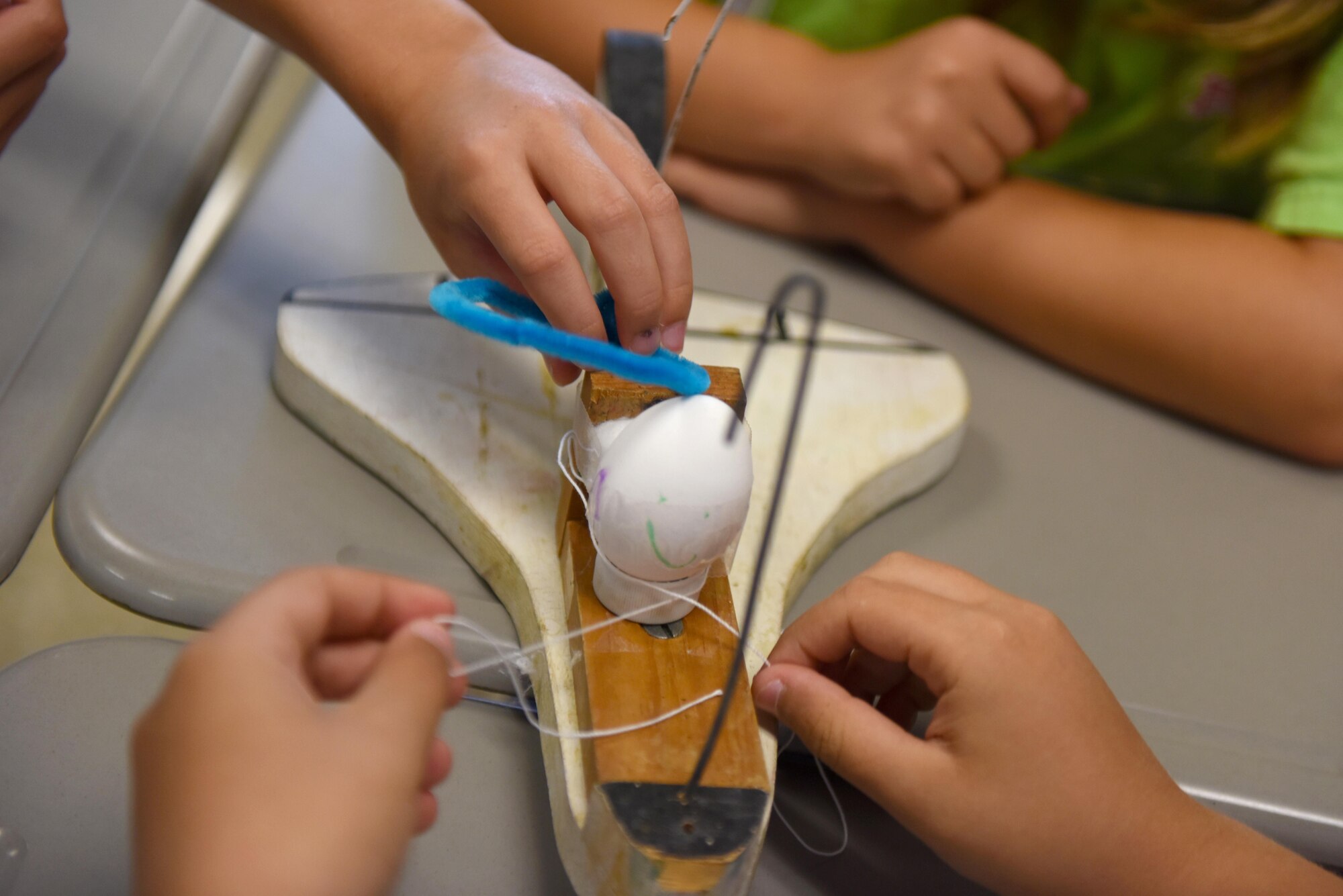 Science and Technology Academies Reinforcing Basic Aviation and Space Exploration students secure an egg to a wooden jet June 22, 2016, at Greenwood Middle School, Goldsboro, North Carolina. Following daily classroom activities, STARBASE students toured Seymour Johnson Air Force Base, North Carolina. (U.S. Air Force photo/Airman 1st Class Ashley Williamson/Released)