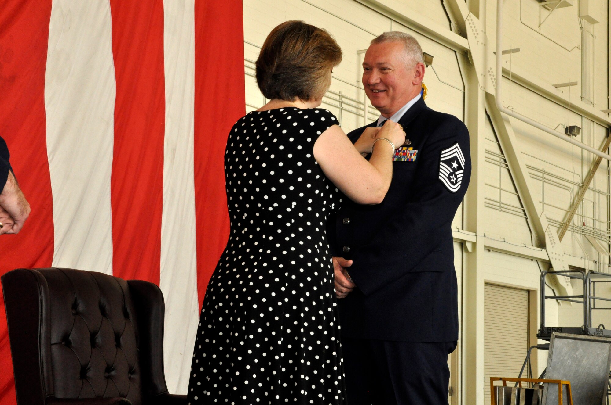 Chief Master Sgt Kevin Warbrick, command chief, 514th Air Mobility Wing, has a retirement pin placed on his lapel by his wife, Eileen during his retirement ceremony held Sunday, here. The command chief is a native of New York and served 33 years in the military.