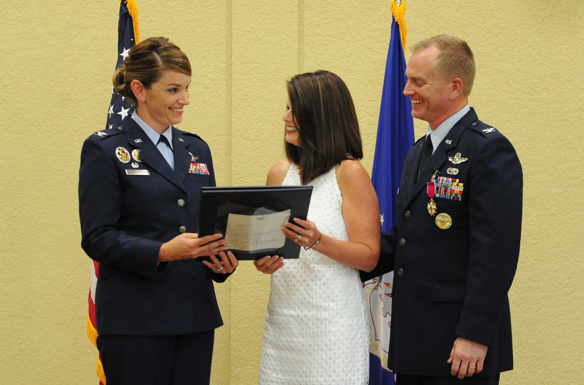 Col. Michele Edmondson, 81st Training Wing commander, presents an Air Force certificate of appreciation to Mary Scarborough, the spouse of Col. Dennis Scarborough, 81st TRW vice commander, during his retirement ceremony at the Bay Breeze Event Center June 28, 2016, on Keesler Air Force Base, Miss. Scarborough retired with 27 years of military service. He has served multiple tours as an F-15C instructor and evaluator and has held positions in the fields of defense policy, operational plans, safety and aircraft maintenance. He has commanded at the squadron level and served as an operations group deputy commander. (U.S. Air Force photo by Kemberly Groue/Released)