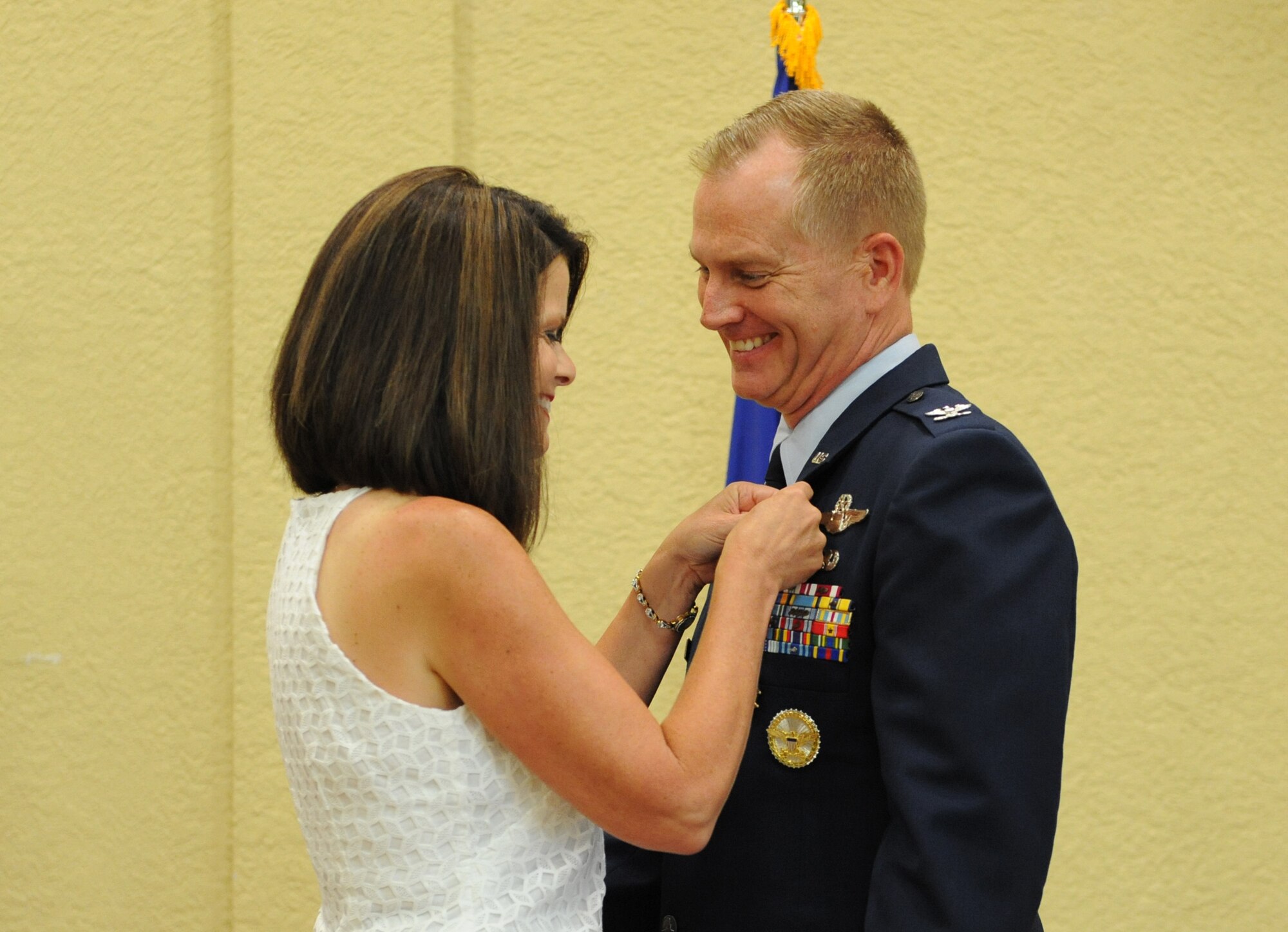 Mary Scarborough presents a retirement pin to her husband, Col. Dennis Scarborough, 81st Training Wing vice commander, during his retirement ceremony at the Bay Breeze Event Center June 28, 2016, on Keesler Air Force Base, Miss. Scarborough retired with 27 years of military service. He has served multiple tours as an F-15C instructor and evaluator and has held positions in the fields of defense policy, operational plans, safety and aircraft maintenance. He has commanded at the squadron level and served as an operations group deputy commander. (U.S. Air Force photo by Kemberly Groue/Released)