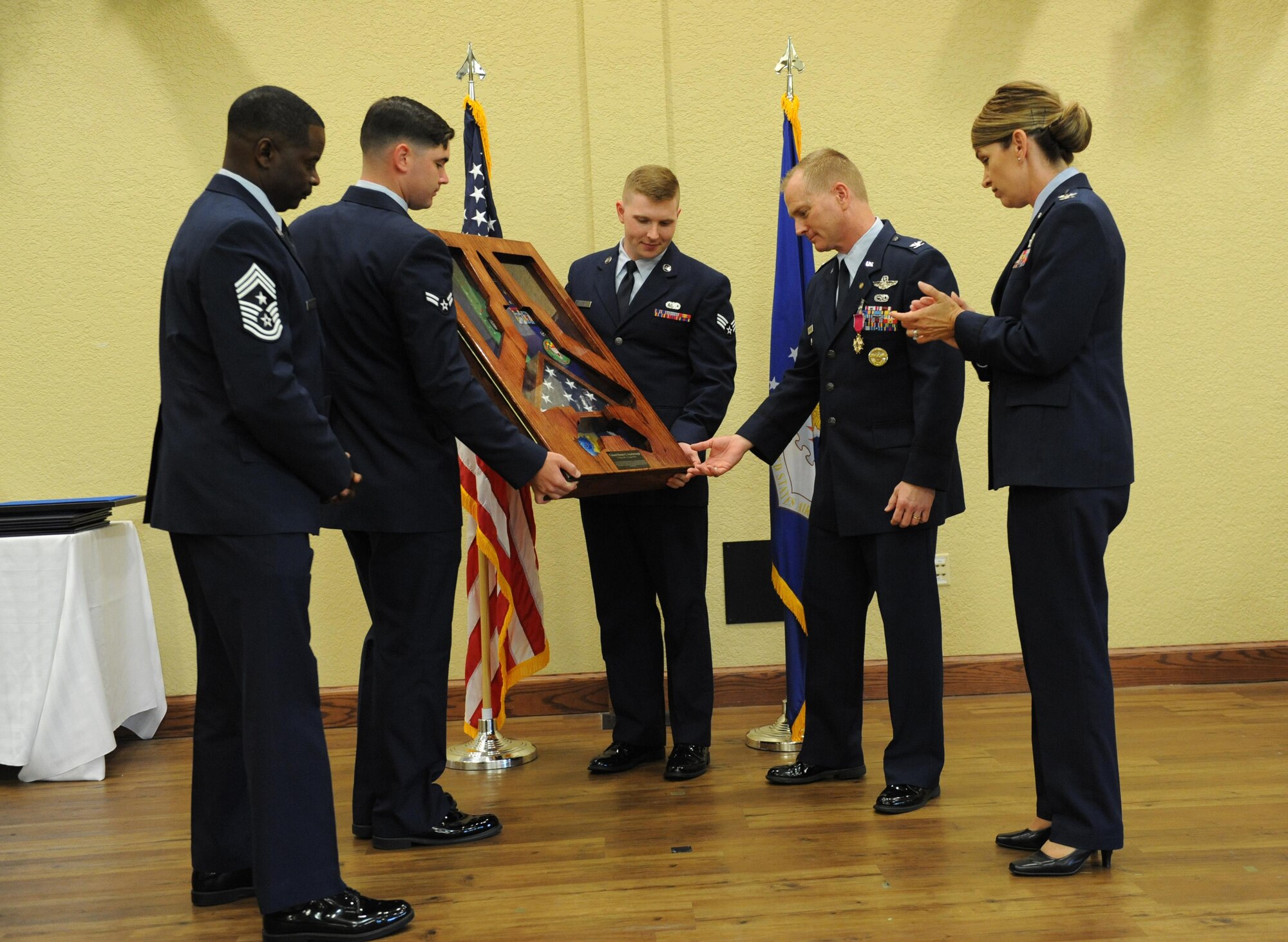 Chief Master Sgt. Harry Hutchinson, 81st Training Wing command chief, and Col. Michele Edmondson, 81st TRW commander, presents a gift on behalf of the 81st TRW to Col. Dennis Scarborough, 81st TRW vice commander, during his retirement ceremony at the Bay Breeze Event Center June 28, 2016, on Keesler Air Force Base, Miss. Scarborough retired with 27 years of military service. He has served multiple tours as an F-15C instructor and evaluator and has held positions in the fields of defense policy, operational plans, safety and aircraft maintenance. He has commanded at the squadron level and served as an operations group deputy commander. (U.S. Air Force photo by Kemberly Groue/Released)