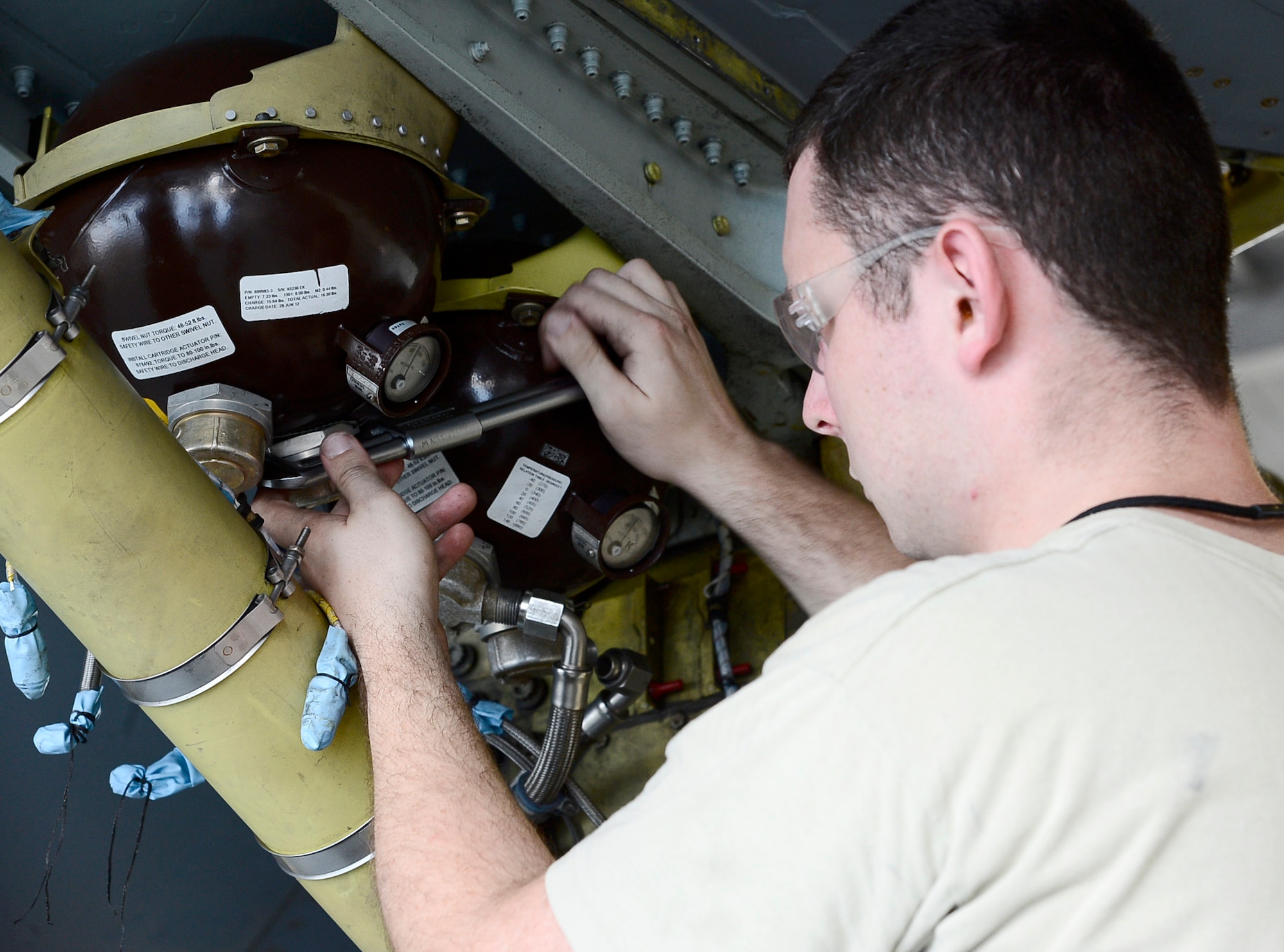Senior Airman Andrew Mayer, an electrical and environmental technician assigned to the 6th Maintenance Squadron, installs an engine fire bottle during a hard landing inspection at MacDill Air Force Base, Fla., June 28, 2016. Airmen systematically dismantled the KC-135 Stratotanker from nose to tail to ensure the aircraft was mission ready. (U.S. Air Force photo by Senior Airman Tori Schultz)