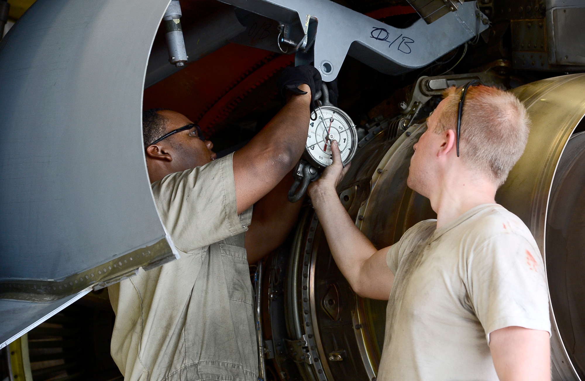 Airman 1st Class Blake Bennett, left, and Senior Airman Cody Evans, right, aerospace propulsion journeymen assigned to the 6th Maintenance Squadron, hang a dynamometer to a portion of a KC- 135 Stratotanker during an inspection at MacDill Air Force Base, Fla., June 28, 2016. Dynamometers are used to measure the amount of weight on the engine trailer. The inspection was conducted to ensure the aircraft was mission ready after a hard landing. (U.S. Air Force photo by Senior Airman Tori Schultz)