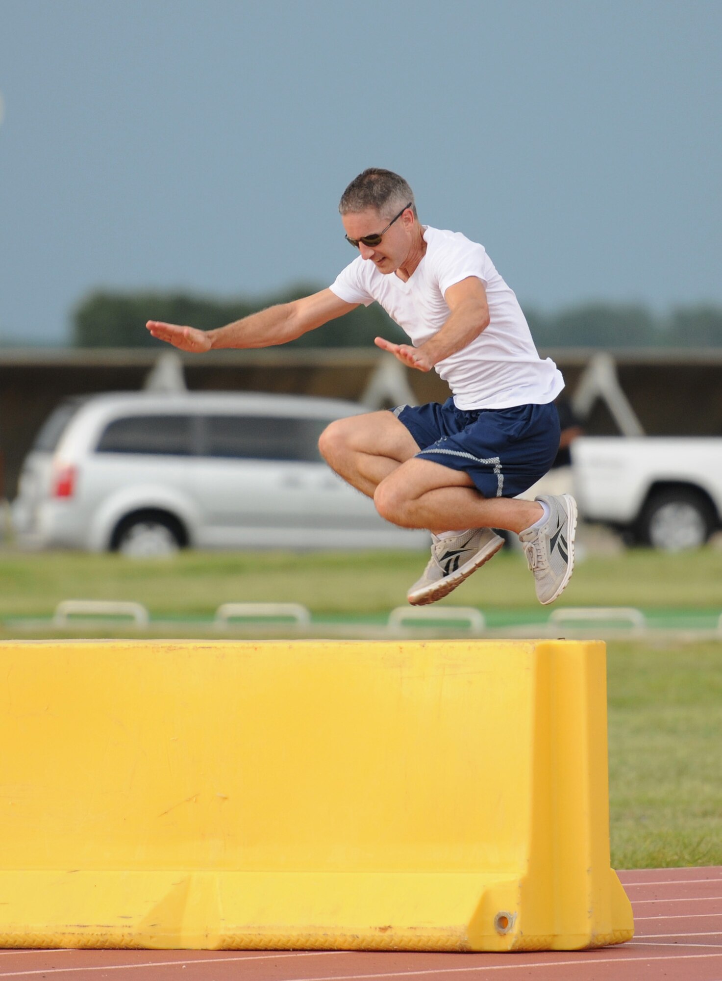 Staff Sgt. Daniel Meeks, 335th Training Squadron student, jumps over a barrier during the Obstacle Warrior Dash 5K at the Triangle track June 27, 2016, on Keesler Air Force Base, Miss. The 81st Force Support Squadron-sponsored event involved participants completing a 5K run then making their way through eight different obstacles. (U.S. Air Force photo by Kemberly Groue/Released)