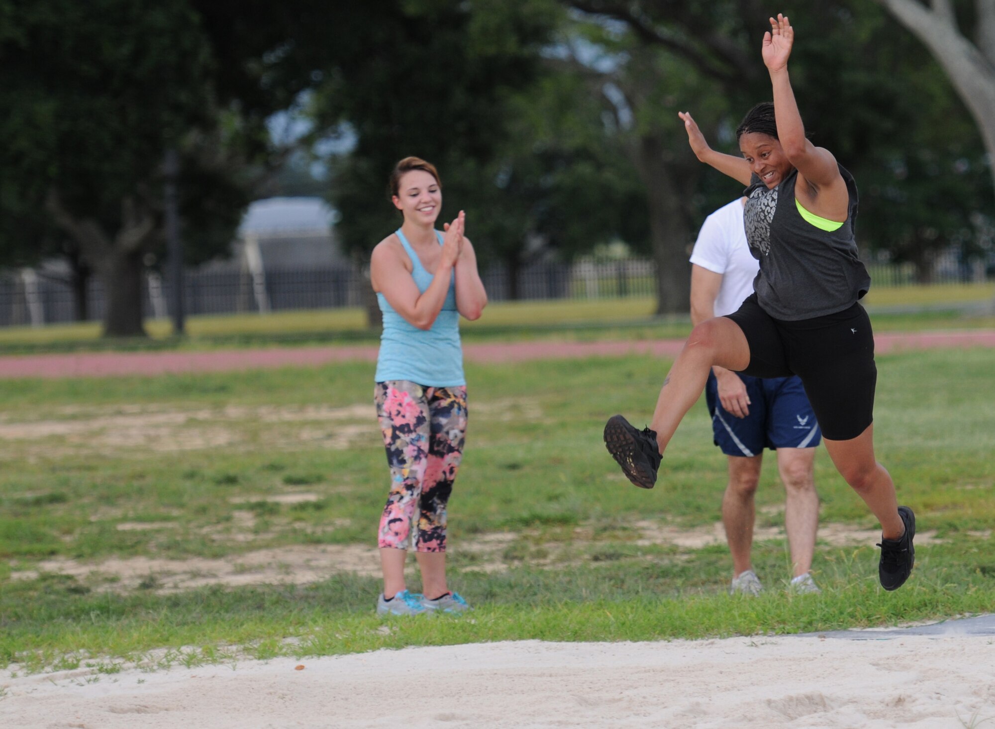 Staff Sgt. Ashley Parker, 335th Training Squadron student, leaps into a sand pit during the Obstacle Warrior Dash 5K at the Triangle track June 27, 2016, on Keesler Air Force Base, Miss. The 81st Force Support Squadron-sponsored event involved participants completing a 5K run then making their way through eight different obstacles. (U.S. Air Force photo by Kemberly Groue/Released)