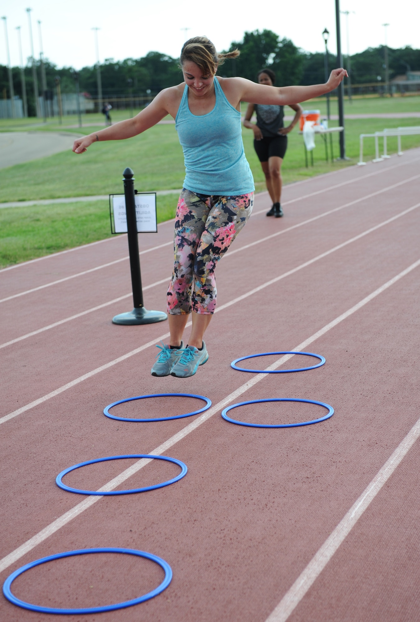 Staff Sgt. Haley May, 335th Training Squadron student, jumps through a 12-foot agility ring course during the Obstacle Warrior Dash 5K at the Triangle track June 27, 2016, on Keesler Air Force Base, Miss. The 81st Force Support Squadron-sponsored event involved participants completing a 5K run then making their way through eight different obstacles. (U.S. Air Force photo by Kemberly Groue/Released)