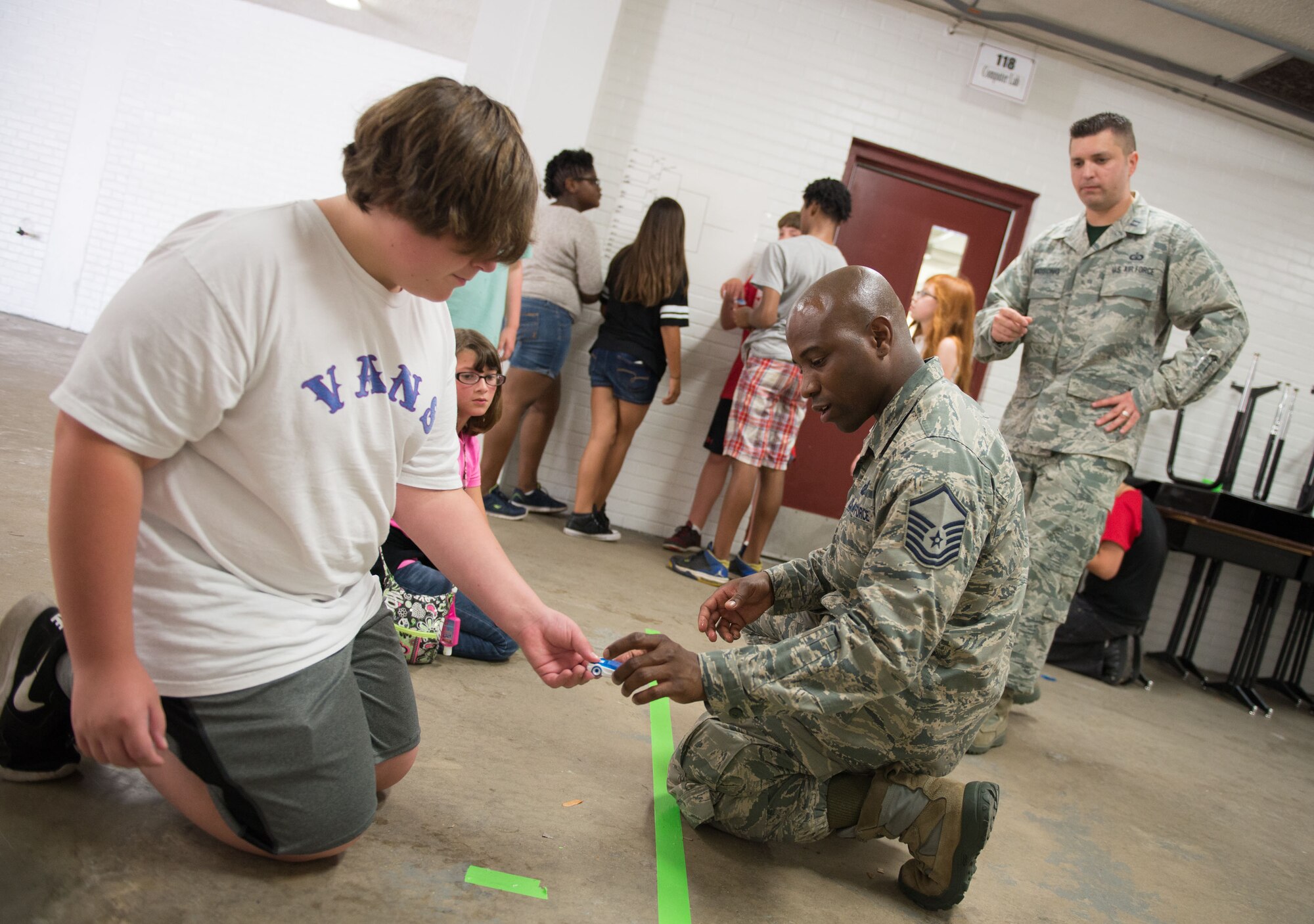 Master Sgt. Al Jervier, 335th Training Squadron instructor and curriculum developer course writer, assists a student before a salt water fuel cell car race during a Science, Technology, Engineering, and Mathematics Camp on June 24, 2016, at Biloxi Junior High School, Biloxi, Miss. Keesler instructors educated students about new forms of clean energy during a week-long program for fifth, sixth, and seventh graders who are interested in science, technology, engineering, and mathematics. (U.S. Air Force photo by Marie Floyd/Released)

