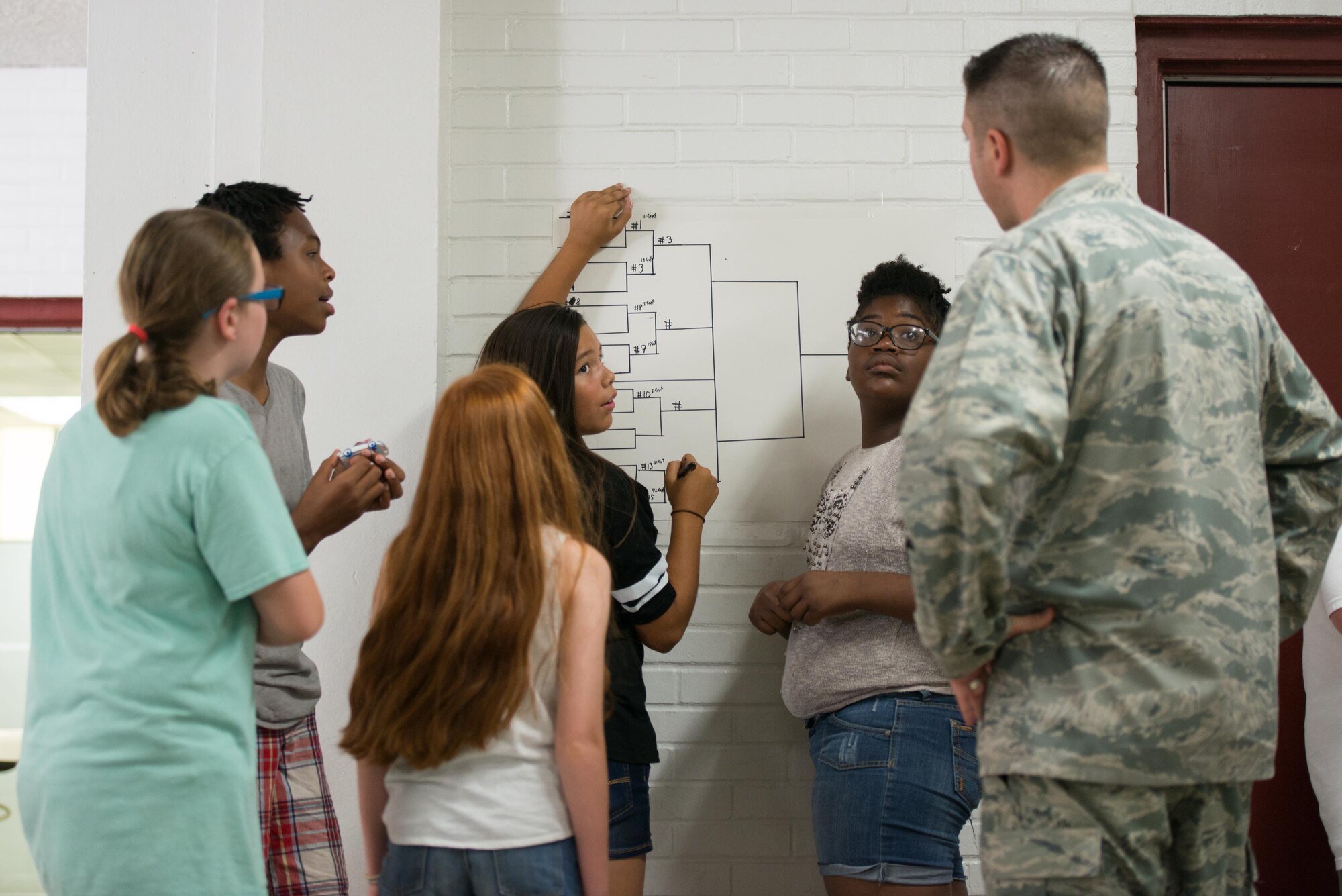 Capt. Gregory Birdsong, 334th Training Squadron instructor, assists students recording data during a Science, Technology, Engineering, and Mathematics Camp on June 24, 2016 at Biloxi Junior High School, Biloxi, Miss. The STEM program is an enrichment program designed for students interested in science, technology, engineering or mathematics. (U.S. Air Force photo by Marie Floyd/Released)