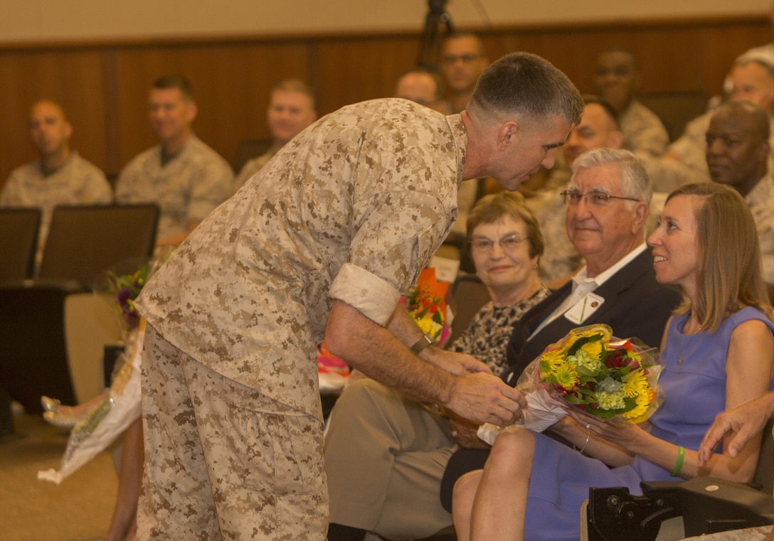 Col. Steven G. Godinho, commanding officer of Headquarters Battalion, MARFORRES, presents his wife with a bouquet of flowers during a change of command ceremony at Marine Corps Support Facility New Orleans, July 1, 2016. Godinho assumed command of Headquarters Battalion in June 2014 and will retire from the Marine Corps after 24 years of faithful service. (U.S. Marine Corps photo by Sgt. Ian Leones/Released)