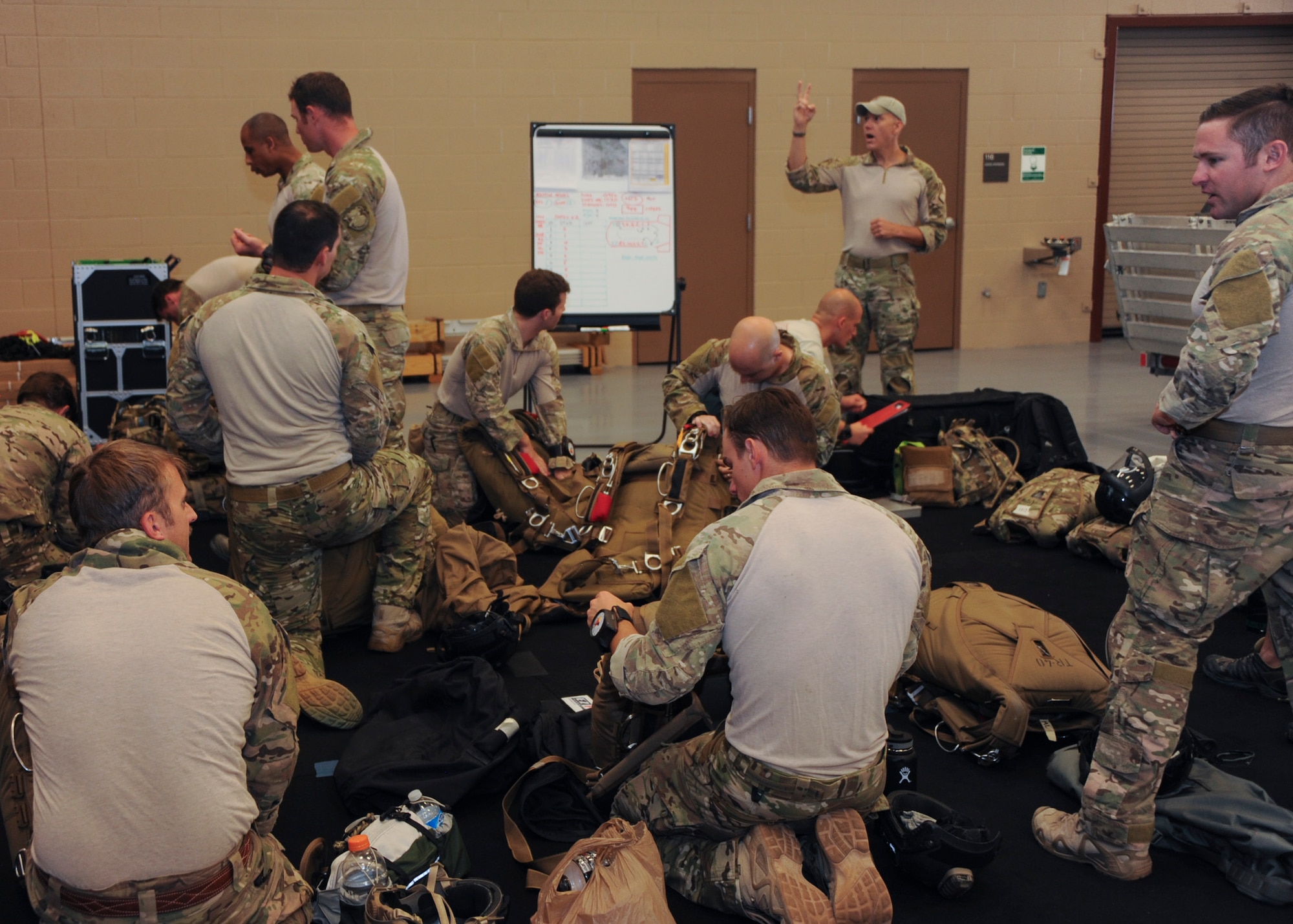 U.S. Airmen prepare equipment during the Military Freefall Jumpmaster Course at Davis-Monthan Air Force Base, Ariz., June 28, 2016. Students vary from tactical air control party specialists, combat controllers, pararescuemen, and survival, evasion, resistance and escape specialists from all different commands. (U.S. Air Force photo by Airman Nathan H. Barbour/Released)