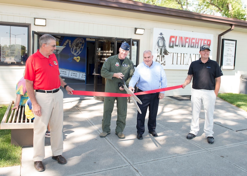 Col. Brian McCarthy, 366th Operations Group commander, cuts a ribbon during the Gunfighter Theater re-opening July 1, 2016, at Mountain Home Air Force Base, Idaho. The theater renovations consisted of improvements to audio visual equipment, stage curtains, the roof, restrooms and more. (U.S. Air Force photo by Airman 1st Class Chester Mientkiewicz/Released)