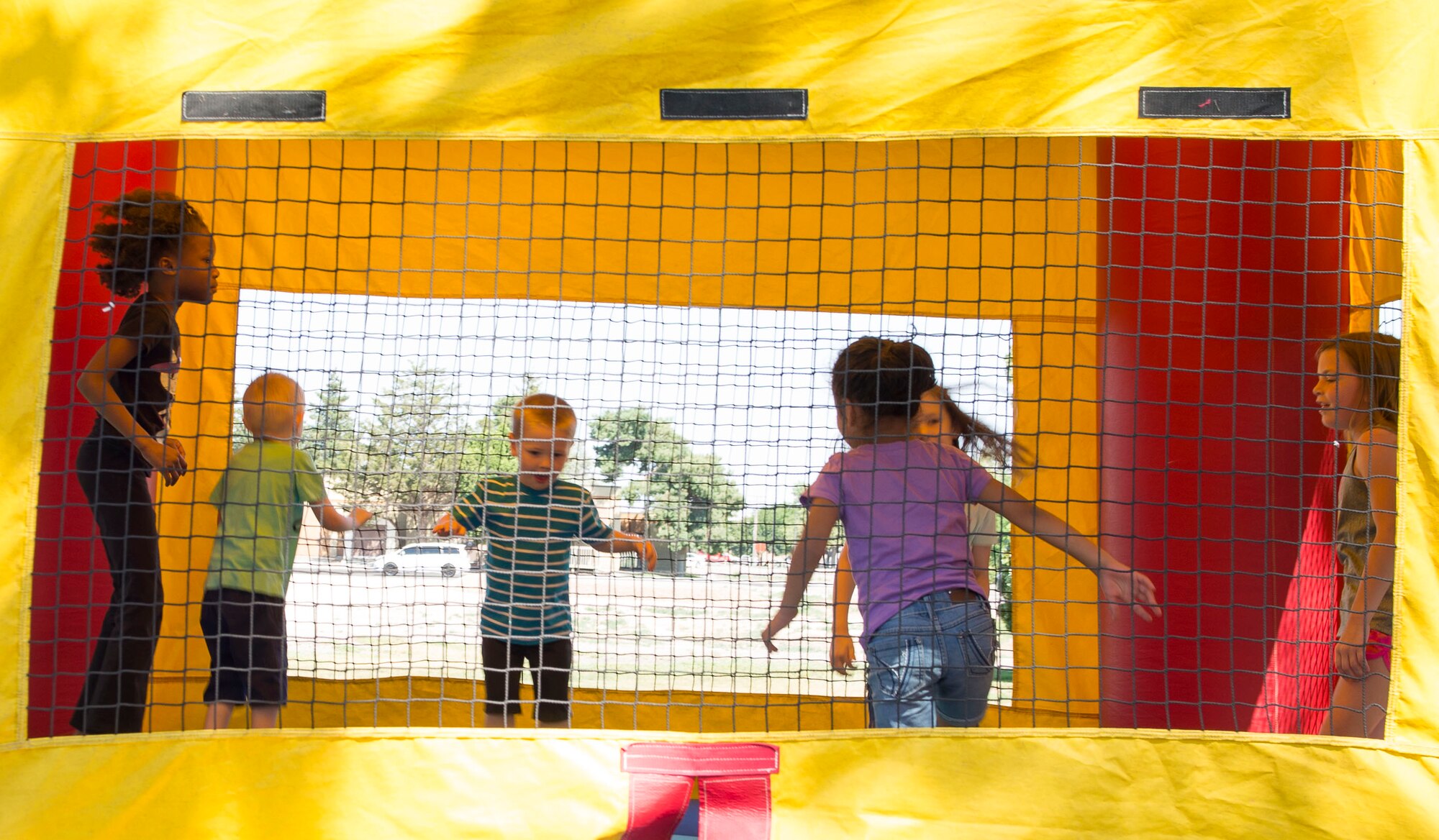 Kids jump in a bouncy house during the 366th Force Support Squadron summer social and Gunfighter Theater re-opening July 1, 2016, at Mountain Home Air Force Base, Idaho. The re-opening of the theater has many excited as movies will be shown again throughout the day. (U.S. Air Force photo by Airman 1st Class Chester Mientkiewicz/Released)