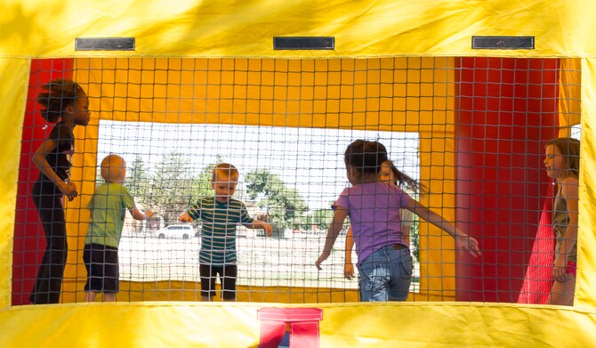 Kids jump in a bouncy house during the 366th Force Support Squadron summer social and Gunfighter Theater re-opening July 1, 2016, at Mountain Home Air Force Base, Idaho. The re-opening of the theater has many excited as movies will be shown again throughout the day. For more information and a movie schedule go to: http://www.mhafbfun.com/theater/schedule.html (U.S. Air Force photo by Airman 1st Class Chester Mientkiewicz/Released)