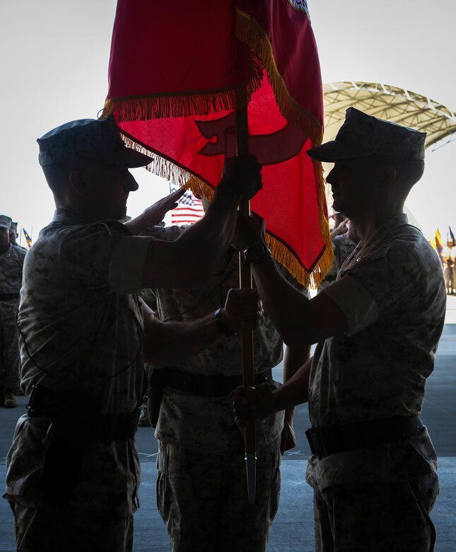 Lt. Col. William Maples (right) passes the flag to Lt. Col. Chad Vaughn (left) as he relinquishes command of the transitioning squadron during a re-designation and change of command ceremony aboard Marine Corps Air Station Yuma, Ariz., June 30. During the ceremony, Marine Attack Squadron (VMA) 211 transitioned to Marine Fighter Attack Squadron (VMFA) 211 making it the first AV-8B Harrier squadron to become an F-35B Lightning II Joint Strike Fighter squadron. (U.S. Marine Corps photo by Lance Cpl. Harley Robinson/Released.)