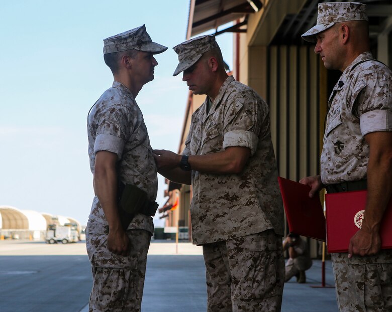 Lt. Col. William Maples is presented a Meritorious Service Medal during a re-designation and change of command ceremony aboard Marine Corps Air Station Yuma, Ariz., June 30. During the ceremony, Marine Attack Squadron (VMA) 211 transitioned to Marine Fighter Attack Squadron (VMFA) 211 making it the first AV-8B Harrier squadron to become an F-35B Lightning II Joint Strike Fighter squadron. (U.S. Marine Corps photo by Lance Cpl. Harley Robinson/Released.)