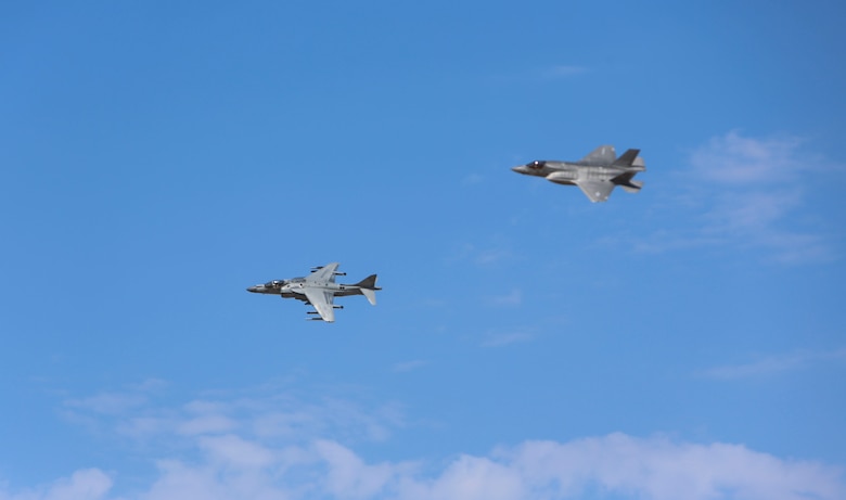 An AV-8B Harrier and an F-35B Lightning II Joint Strike Fighter conduct a flyover during a re-designation and change of command ceremony aboard Marine Corps Air Station Yuma, Ariz., June 30. During the ceremony, Marine Attack Squadron (VMA) 211 transitioned to Marine Fighter Attack Squadron (VMFA) 211 making it the first Harrier squadron to become an F-35 squadron. (U.S. Marine Corps photo by Lance Cpl. Harley Robinson/Released.)
