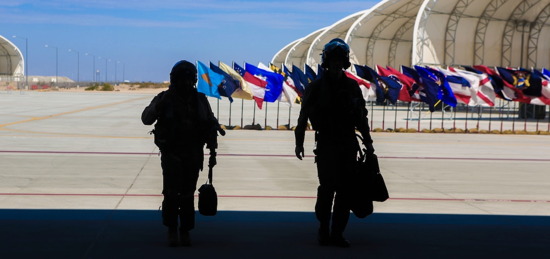 An AV-8B Harrier pilot and an F-35B Lightning II Joint Strike Fighter pilot return from conducting a flyover during a re-designation and change of command ceremony aboard Marine Corps Air Station Yuma, Ariz., June 30. During the ceremony, Marine Attack Squadron (VMA) 211 transitioned to Marine Fighter Attack Squadron (VMFA) 211 making it the first Harrier squadron to become an F-35 squadron. (U.S. Marine Corps photo by Lance Cpl. Harley Robinson/Released.)