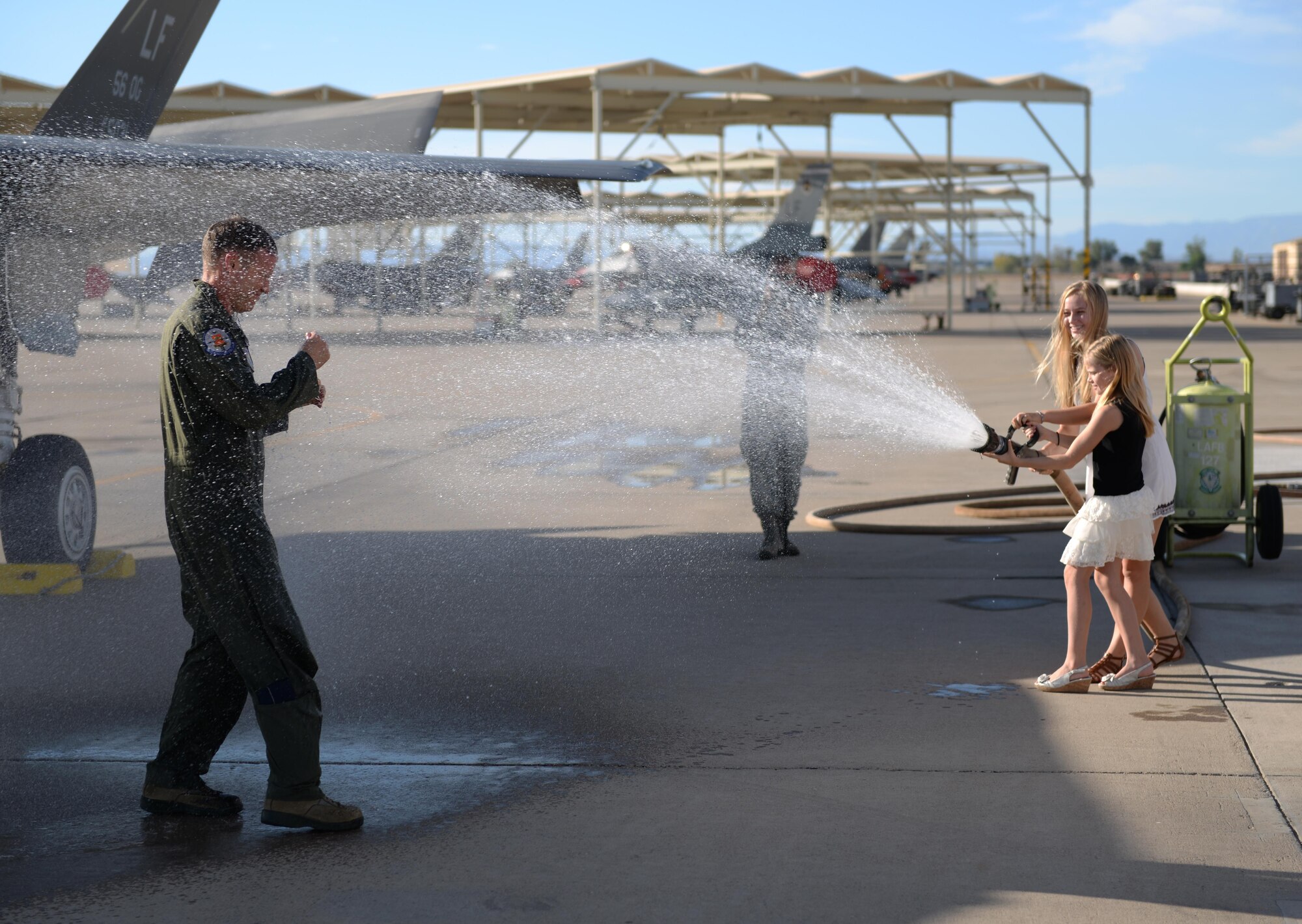 Col. Chris Bailey, 56th Operations Group commander, is sprayed with a fire hose by his family after his final flight in an F-35 Lightning II June 30, 2016. His two-year tenure as commander was filled with change as the wing shifted its mission to include the F-35. (U.S. Air Force photo by Airman 1st Class Ridge Shan)