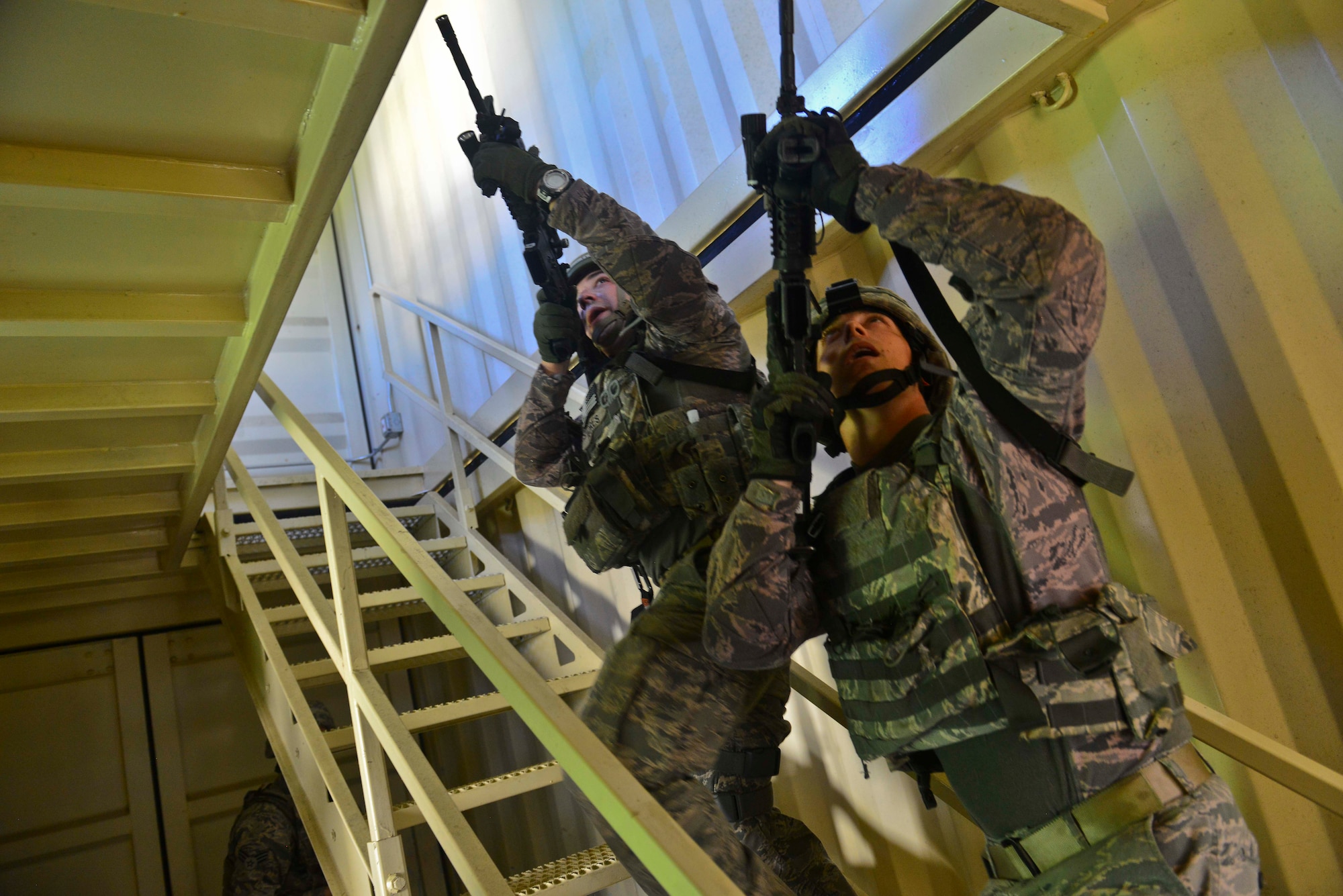U.S. Air Force Staff Sgts. Corie Flores and Ryan Vottero, 633rd Security Forces Squadron Base Defense Operations Center operators clear a mock control tower building during Combat Readiness Training at Langley Air Force Base, Va., June 27, 2016. During the two-day course, SF students were taught; troop leading procedures, base security operations, detainee/enemy prisoner of war procedures, team movement procedures, land navigation, expeditionary entry control point operations, self-aid and buddy care.  (U.S. Air Force photo by/Tech. Sgt. Daylena S. Ricks)