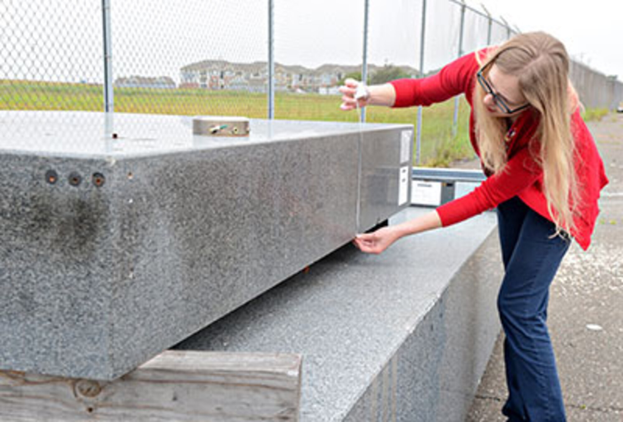 Donna Stacy, Oklahoma City Air Logistics Complex’s corrosion prevention and control program manager, measures 34,000 pounds of granite slabs that were slated to go to a landfill. They will no longer go to waste, as a buyer has purchased them for their use. (Air Force photo by Kelly White/Released)

