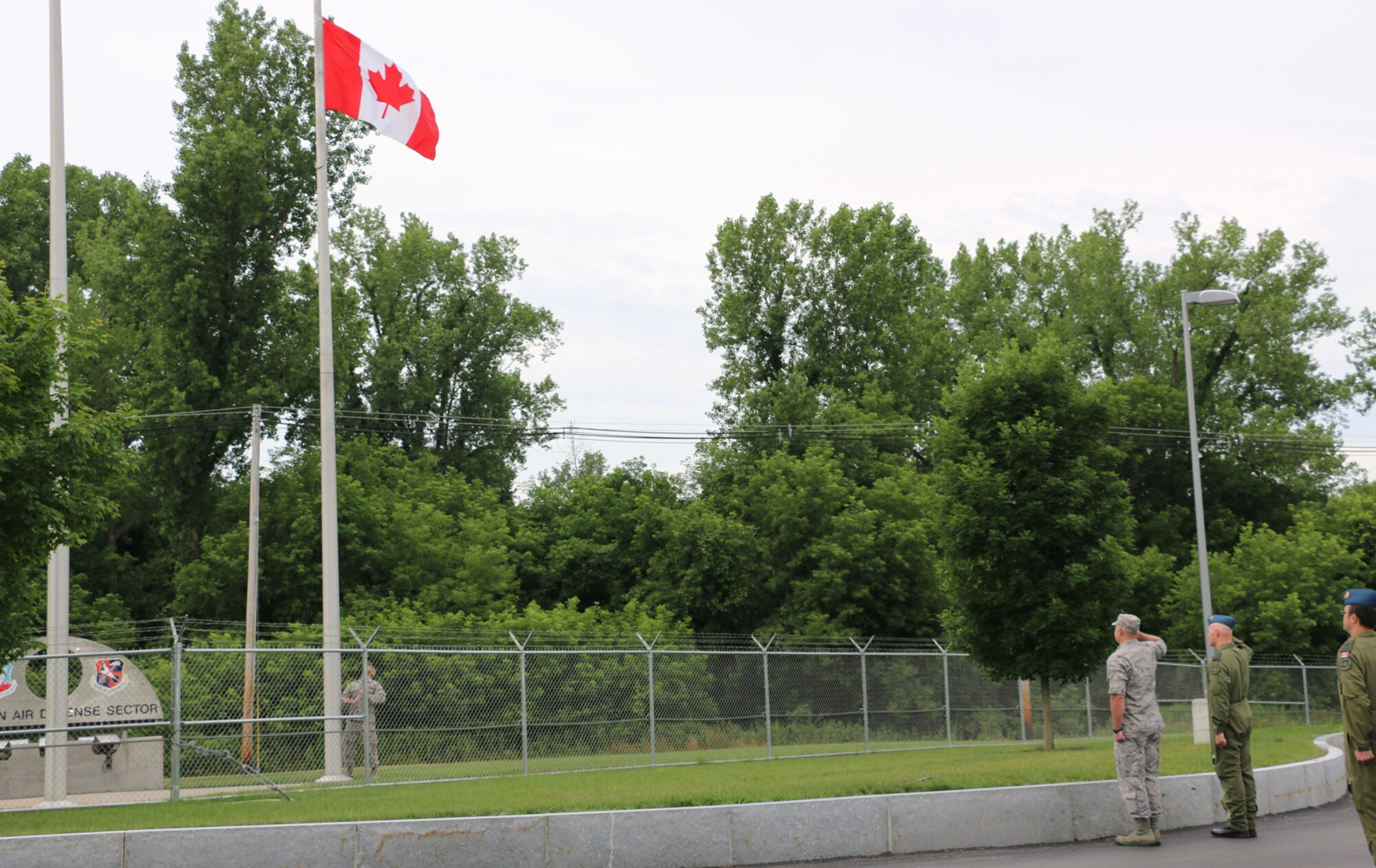 New York Air National Guardsmen and Canadian Forces members at the Eastern Air Defense Sector salute on Friday, July 1, as the Canadian flag is raised. The flag-raising ceremony was in honor of Canada Day, which is celebrated on July 1. EADS is a NORAD headquarters unit, where New York Air National Guardsmen and Canadian Forces work side by side everyday. 