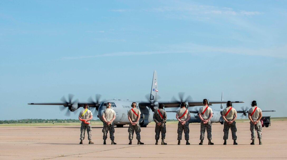 U.S. Air Force Airmen watch as a C-130J Super Hercules prepares to taxi a runway June 18, 2016, at Dyess Air Force Base, Texas. C-130s from Dyess carried the 82nd Airborne Division to the Nevada Test and Training Range in support of a Joint Forcible Entry Exercise. The JFEX is a U.S. Air Force Weapons School large-scale air mobility exercise where all participants had to plan and execute an air-land operation in a simulated dangerous environment. (U.S. Air Force photo by Airman 1st Class Austin Mayfield/ Released)