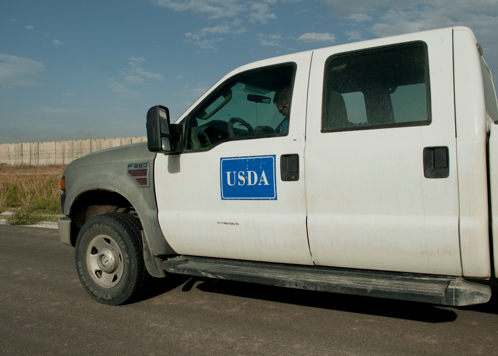Mr. Ben Allen prepares to exit a vehicle on the flightline to conduct wildlife mitigation tactics, June 30, 2016, Bagram Airfield Afghanistan. Allen works for the U.S. Department of Agriculture through a partnership with the U.S. Air Force at Bagram Airfield to help mitigate the impact wildlife has on flying operations. (U.S. Air Force photo by Capt. Korey Fratini)