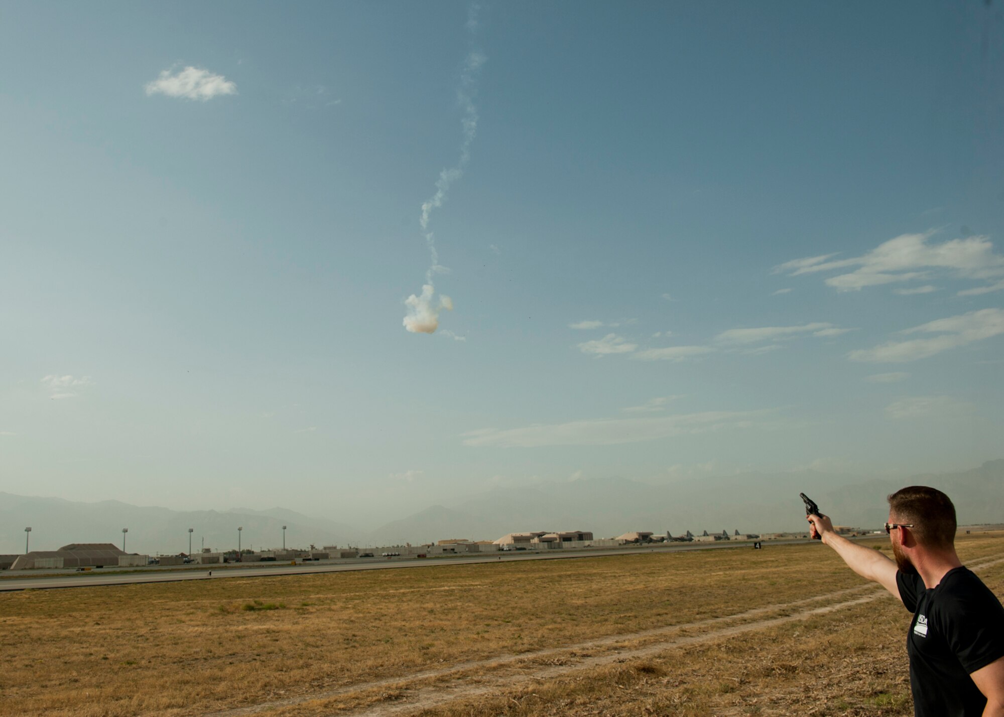 Mr. Ben Allen, U.S. Department of Agriculture Wildlife Services wildlife specialist and biologist, fires a pyrotechnic pistol, June 30, 2016, Bagram Airfield, Afghanistan. Pyrotechnic pistols are used as a tactic to scare birds and other wildlife that are around the airfield in order to create an environment safe enough for air operations. (U.S. Air Force photo by Capt. Korey Fratini)
