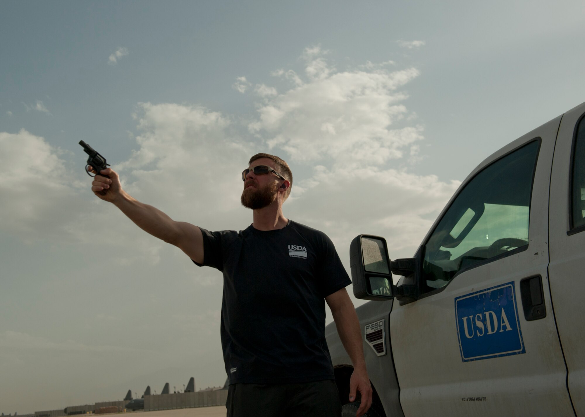 Mr. Ben Allen, U.S. Department of Agriculture Wildlife Services wildlife specialist and biologist, prepares to fire a pyrotechnic pistol, June 30, 2016, Bagram Airfield, Afghanistan. Pyrotechnic pistols are used as a tactic to scare and deter birds and other wildlife that are around the airfield in order to create an environment safe enough for air operations. (U.S. Air Force photo by Capt. Korey Fratini)