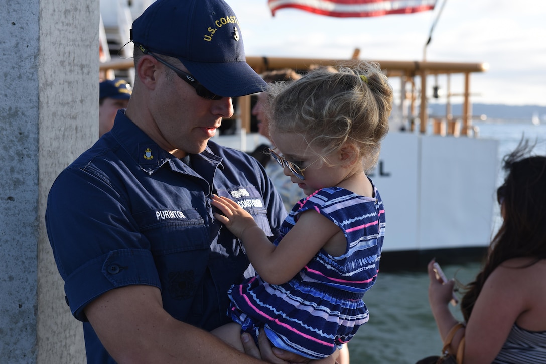 Chief Petty Officer Nathan Purinton, executive officer of the Coast Guard Cutter Haddock, embraces his daughter after returning to home port at Coast Guard Sector San Diego, Calif., July 3, 2016. Coast Guard photo by Petty Officer 3rd Class Joel Guzman