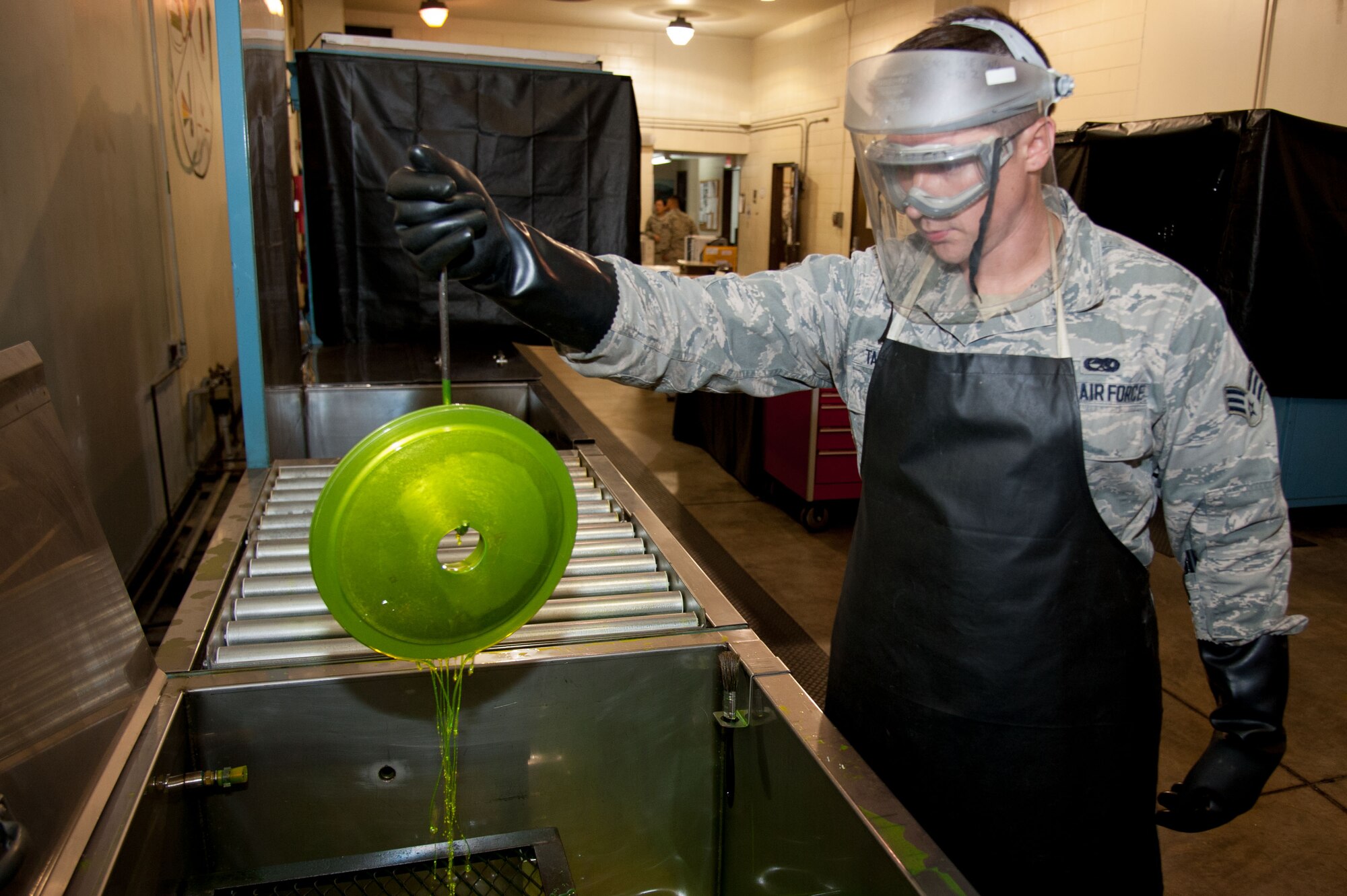 Senior Airman Nathan Talamantez, 51st Maintenance Squadron non-destructive inspection journeyman, pulls out a brake housing covered in florescent oil penetrate at Osan Air Base, Republic of Korea, June 28, 2016. Talamantez will use florescent oil penetrate to identify cracks in aircraft parts. Talamantez is assigned to the non-destructive inspection shop and is part of the fabrication flight which also has structural maintenance shop and metals technology. Fabrication flight Airmen identify, repair and build parts to working order so that Osan airframes are ready to fight tonight.  (U.S. Air Force photo by Staff Sgt. Jonathan Steffen/Released)