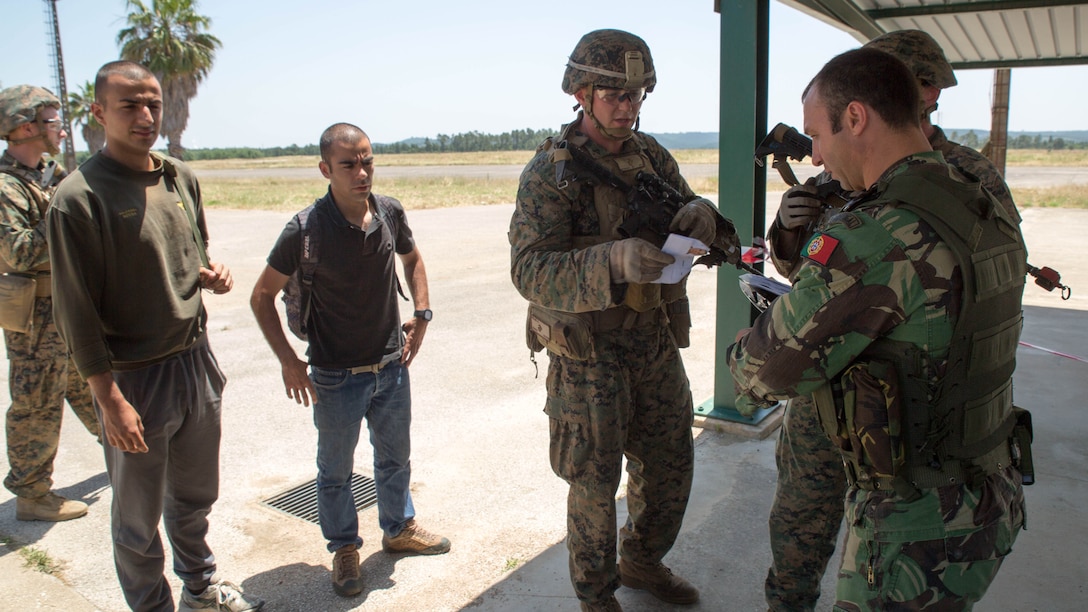 U.S. Marine Corps Lance Cpl. Kevin Miller, a machine gunner with Special Purpose Marine Air-Ground Task Force-Crisis Response-Africa, transfers two simulated refugees to Portuguese authority during a non-combatant evacuation operation as part of Exercise Orion 16 at military training area Tancos, Portugal, June 23, 2016. This training gave the Marines an opportunity to work side by side the Portuguese military, providing invaluable experience for future joint operations. 