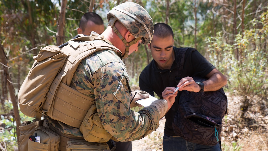 U.S. Marine Corps Lance Cpl. Kevin Miller, a machine gunner with Special Purpose Marine Air-Ground Task Force-Crisis Response-Africa, verifies the identities of two simulated refugees during Exercise Orion 16 in Santa Margarida, Portugal, June 23, 2016. This training gave the Marines an opportunity to work side by side the Portuguese military, providing invaluable experience for future joint operations. 